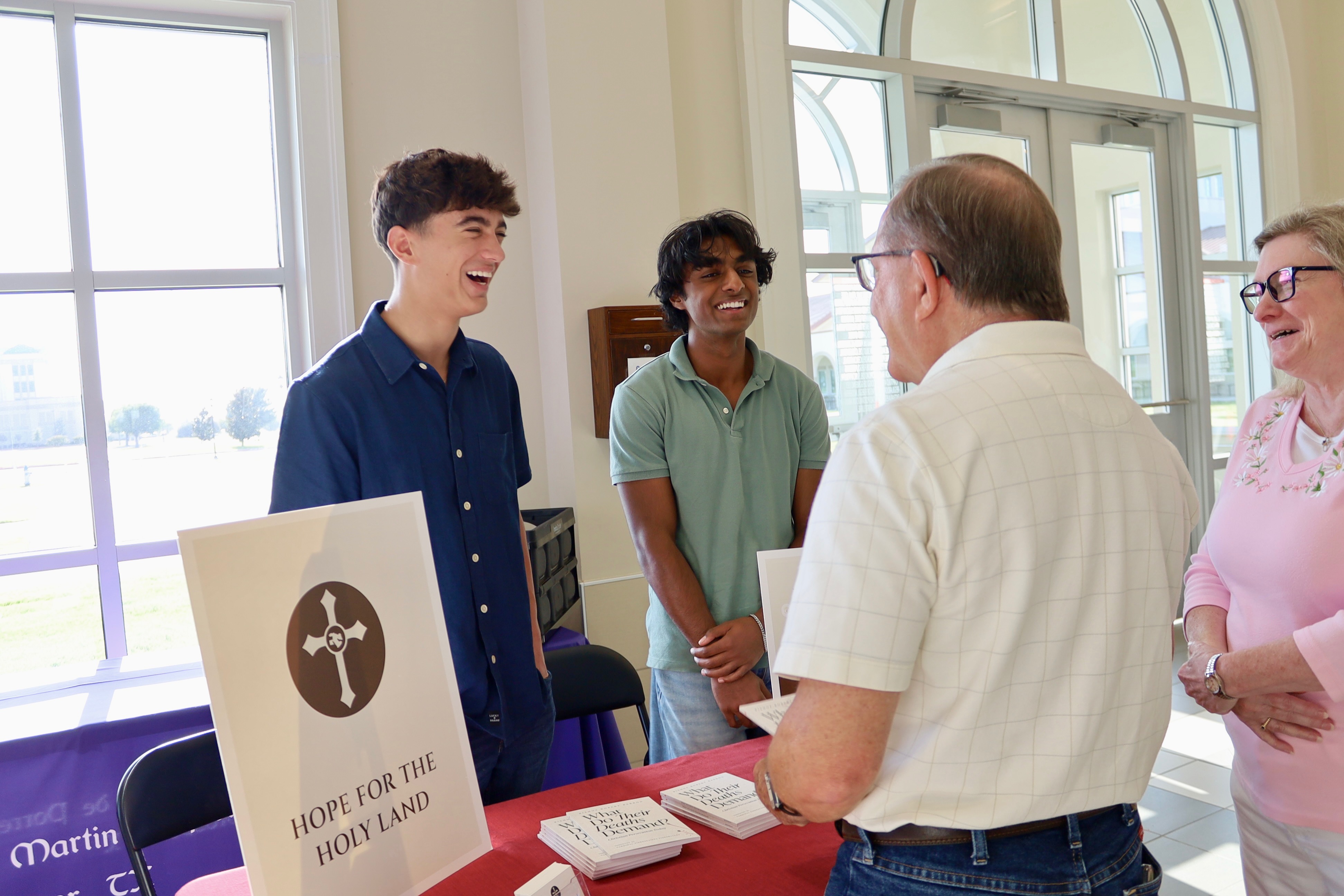 The founders sharing a laugh with parishioners at the Hope for the Holy Land outreach table
