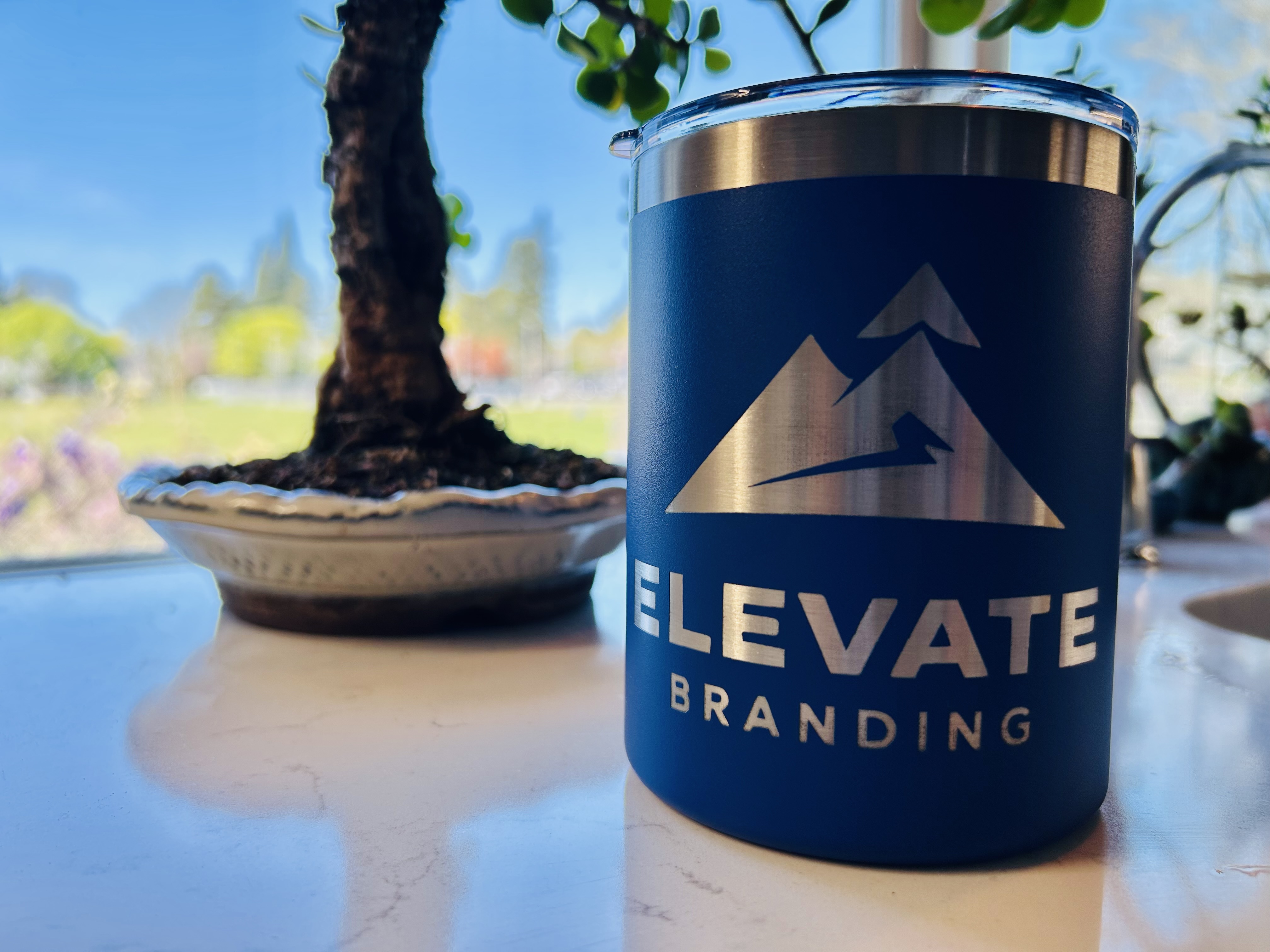 Blue Elevate Branding tumbler with laser-engraved mountain logo