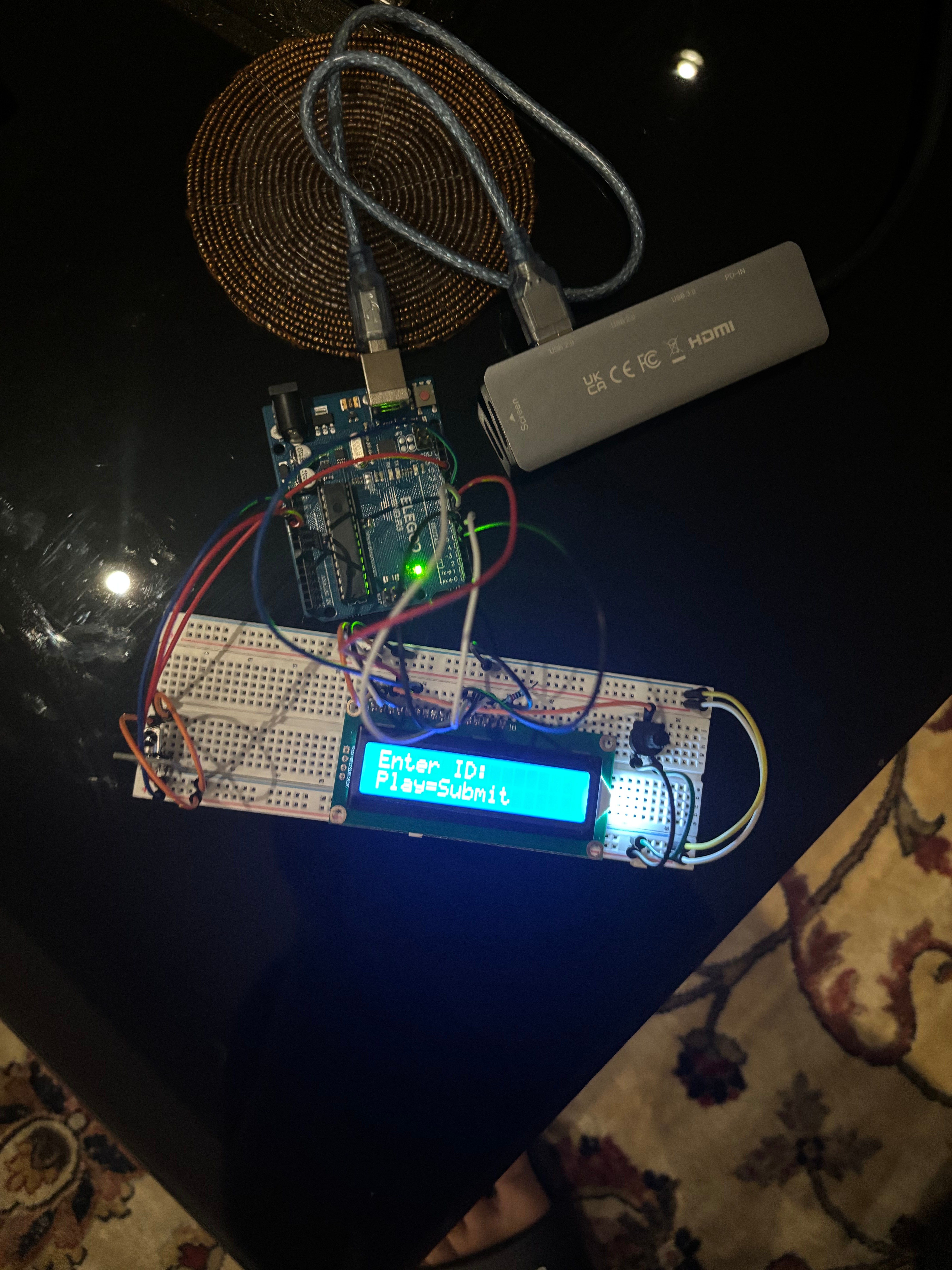 Breadboard prototype with an Arduino Uno, IR receiver, and 16x2 LCD displaying 'Enter ID: Play=Submit'