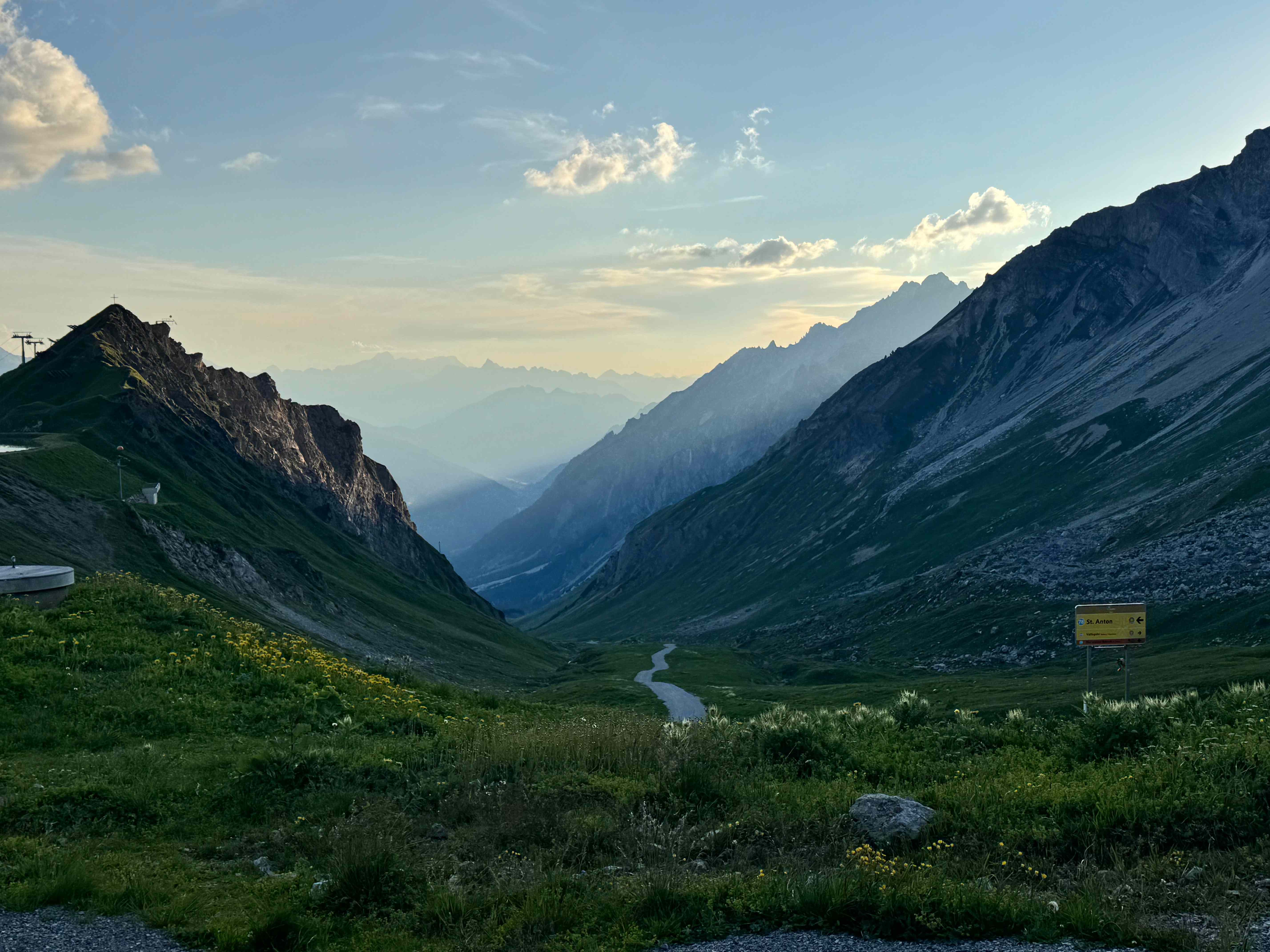 Bergtal im Abendlicht mit geschwungenem Weg Richtung St. Anton