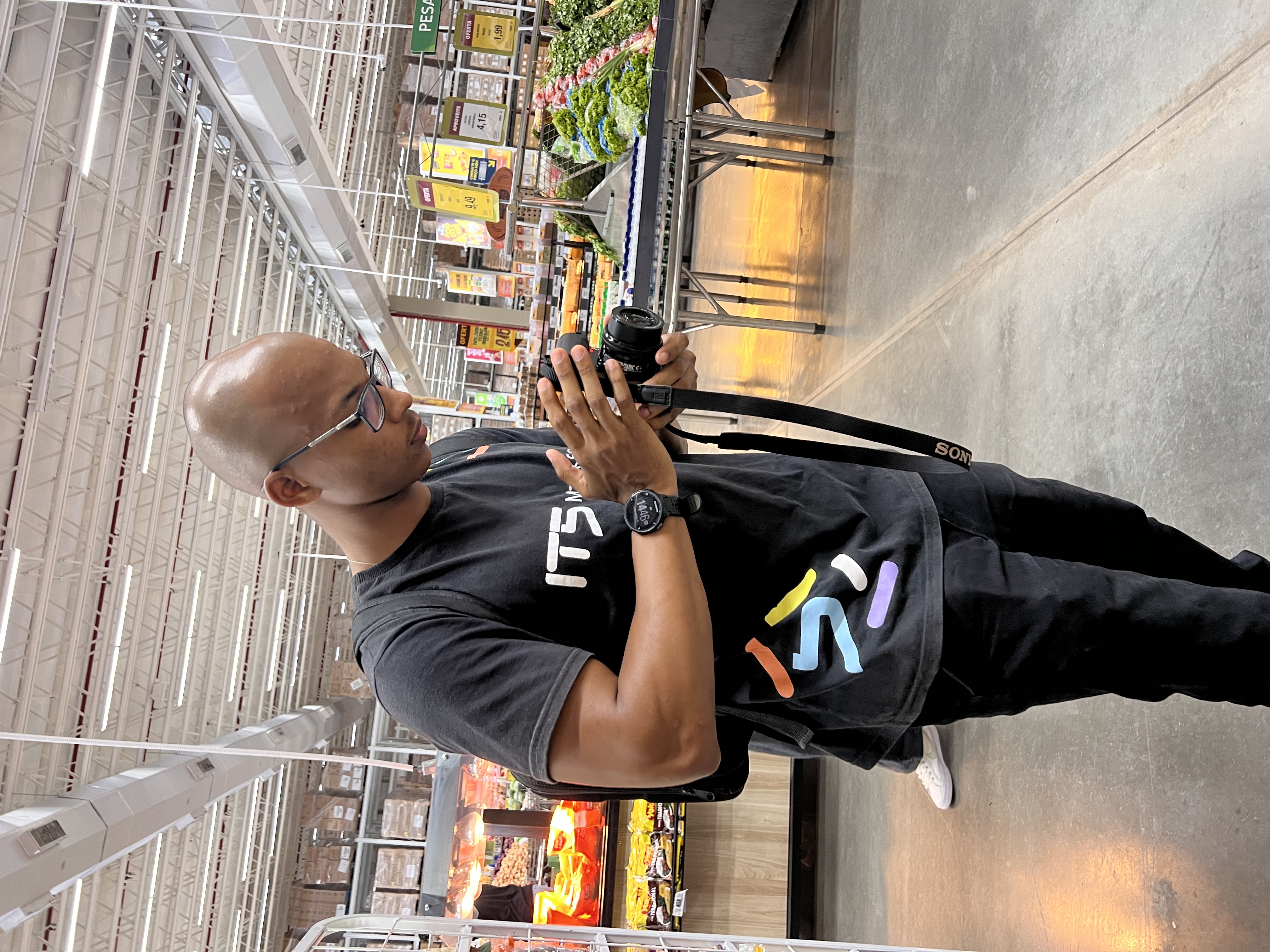 Fotógrafo IT5 com câmera em supermercado