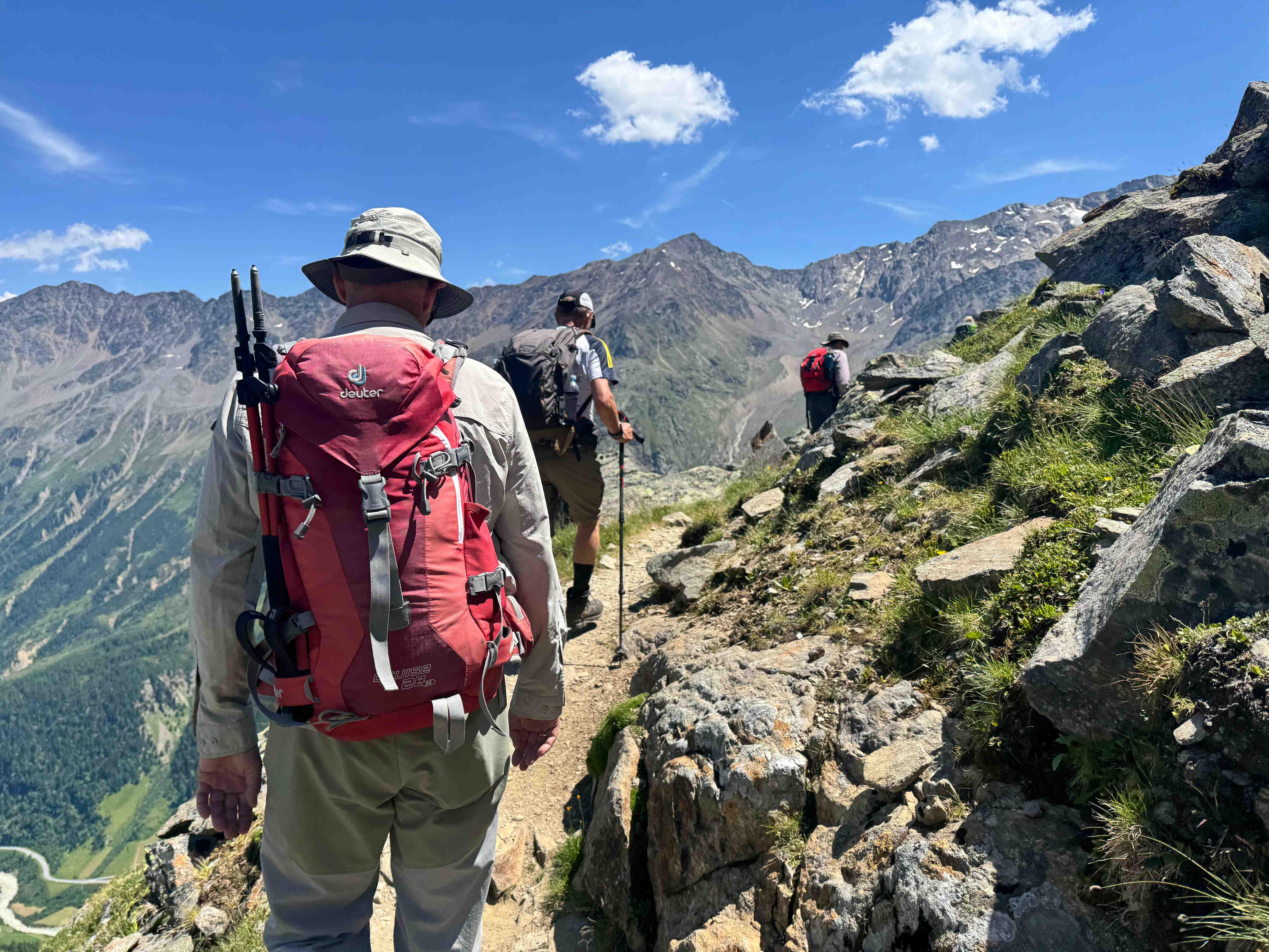 Wanderer auf einem schmalen Grat mit Bergpanorama