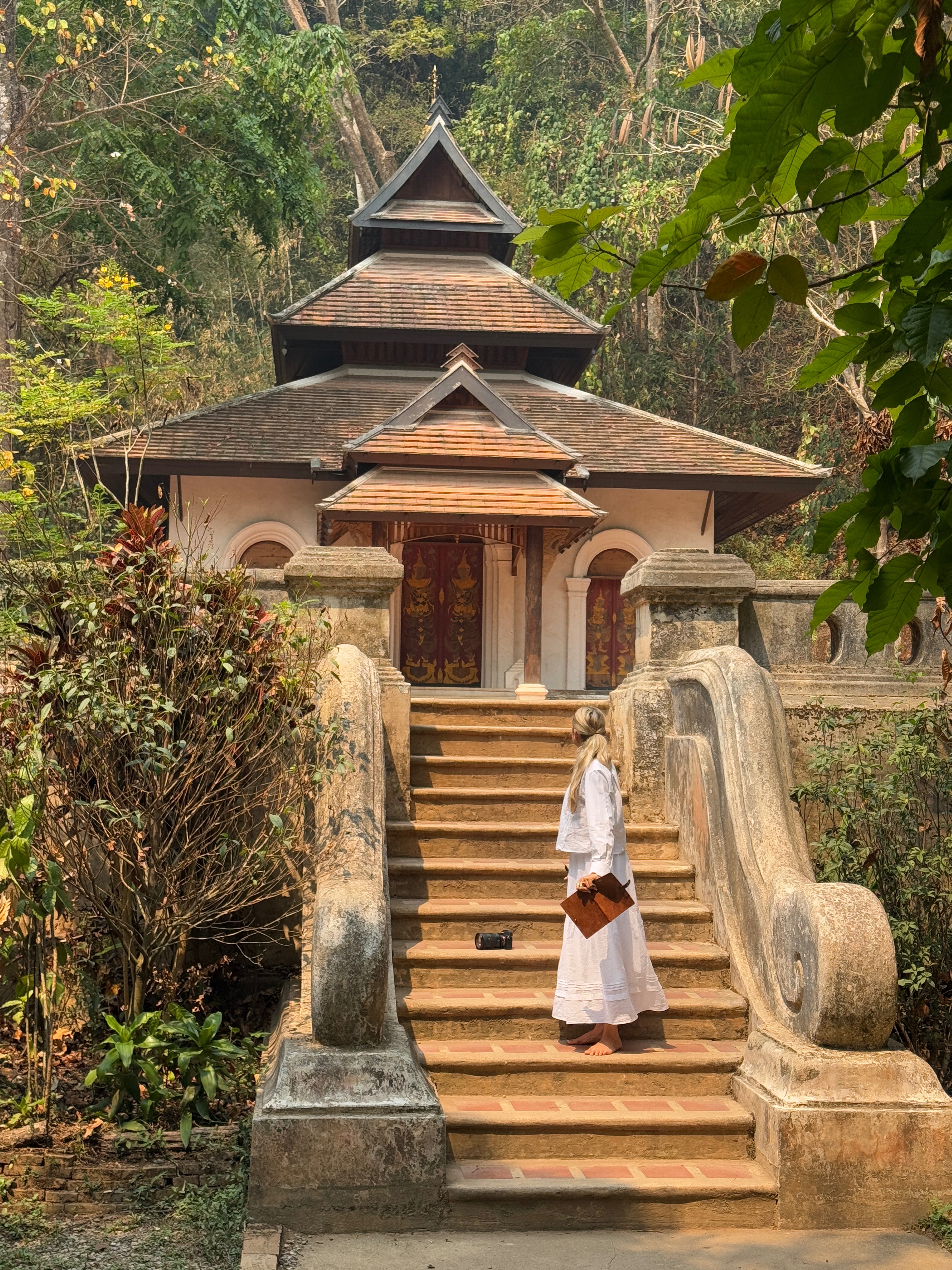 Walking up stone steps to ornate Thai temple
