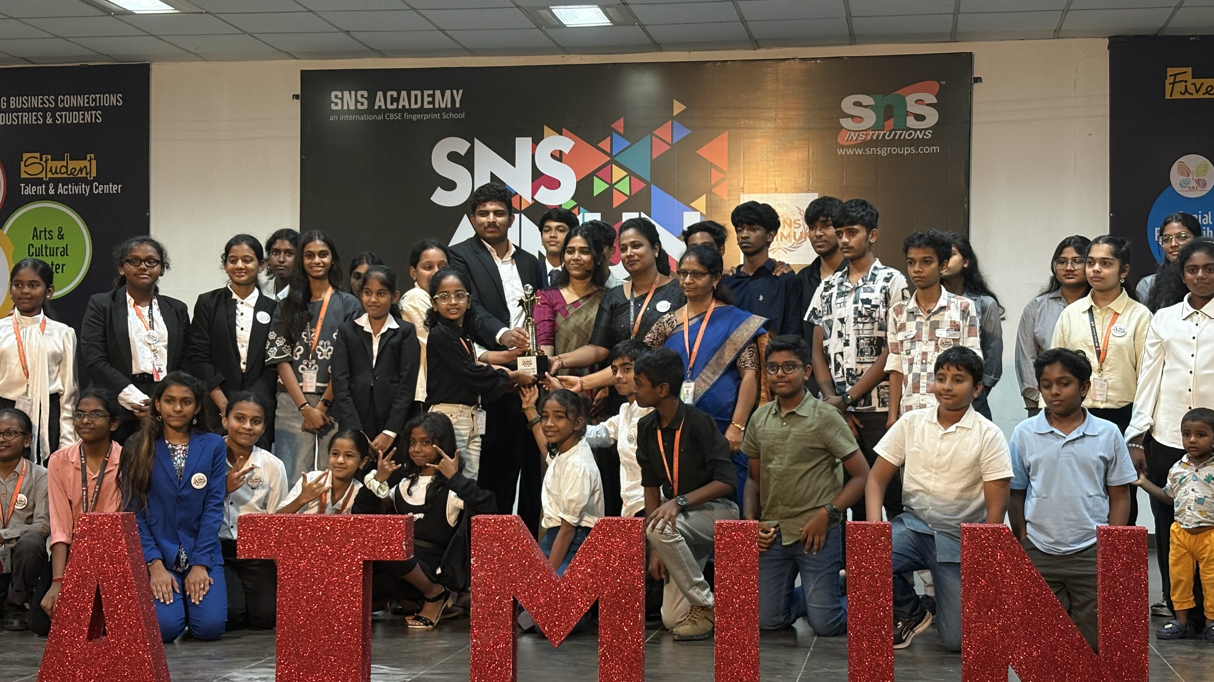 Delegates and faculty posing in front of the conference stage
