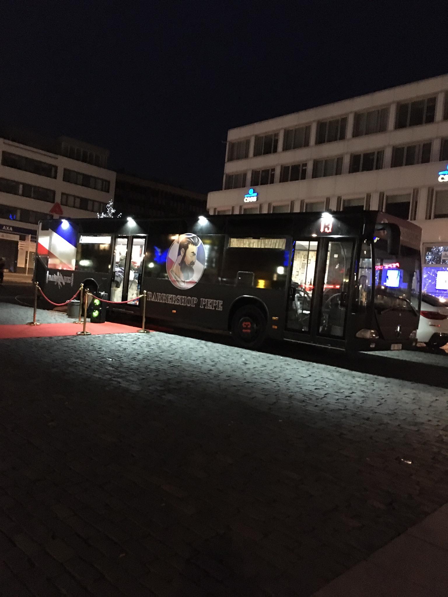 Barbershop bus v noci s červeným kobercem