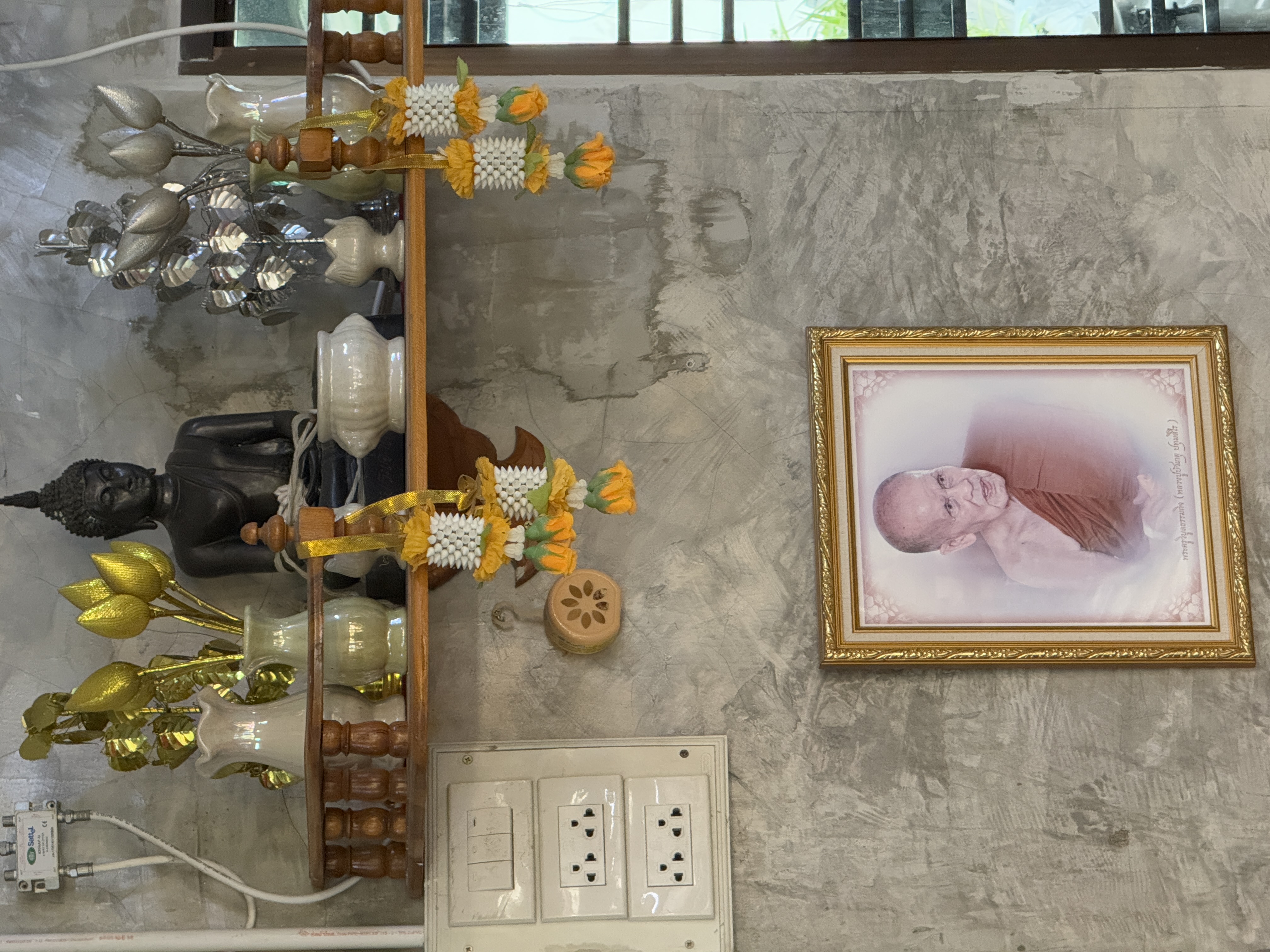 Buddhist shrine with marigold garlands and monk portrait