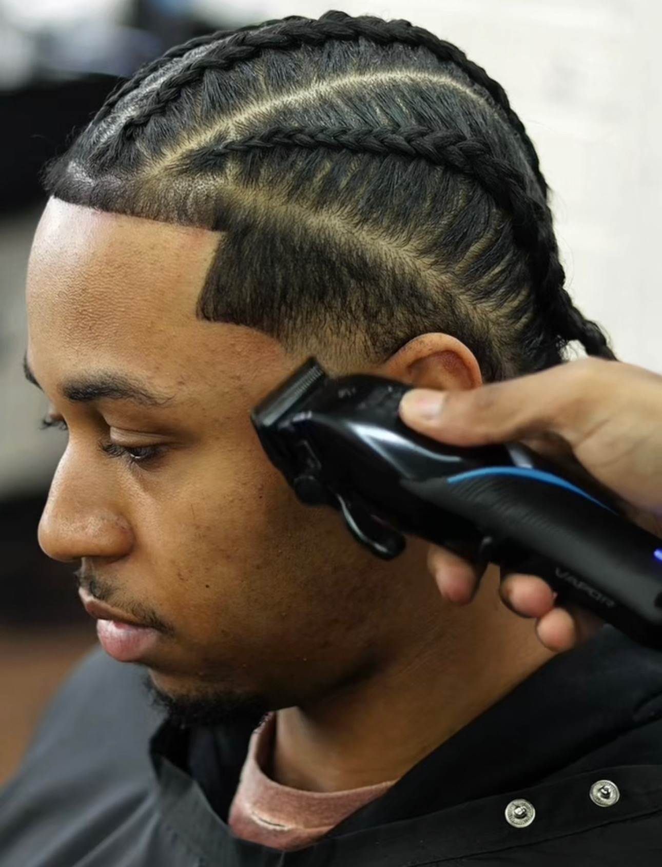 Braided haircut being shaped with clippers