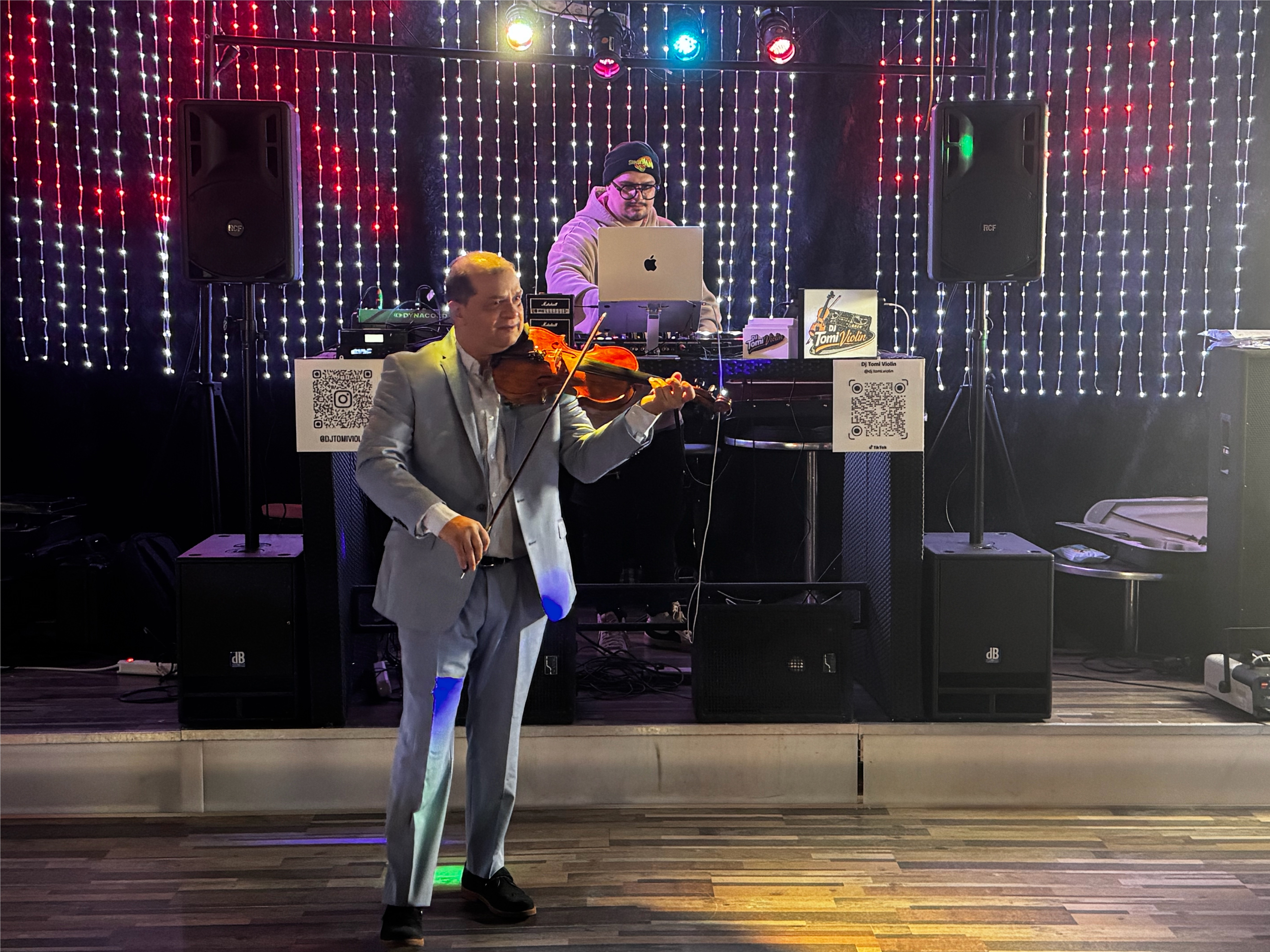 Tomislav spielt Violine während sein Sohn das DJ-Pult übernimmt