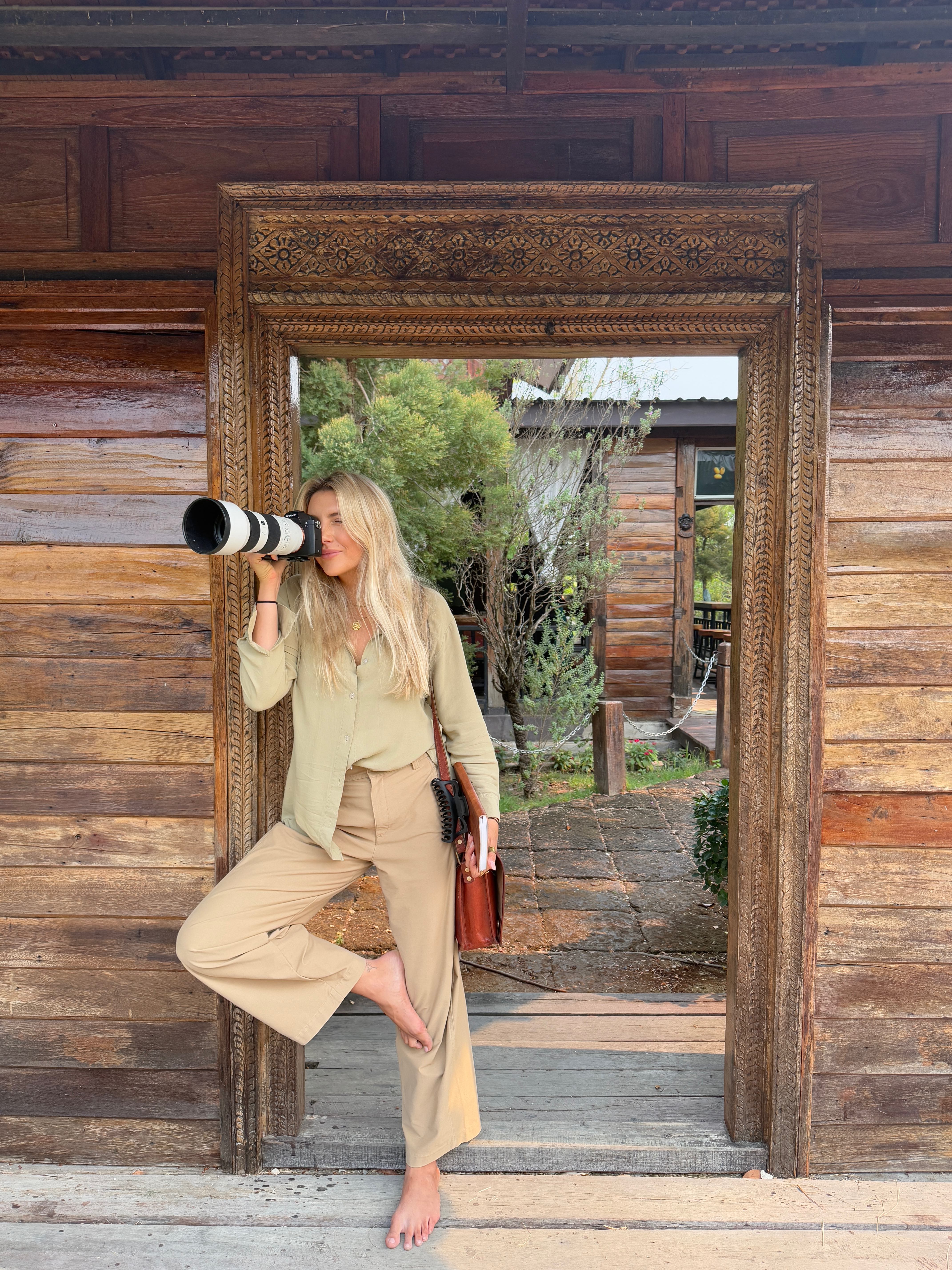 Posing with camera in carved wooden doorframe