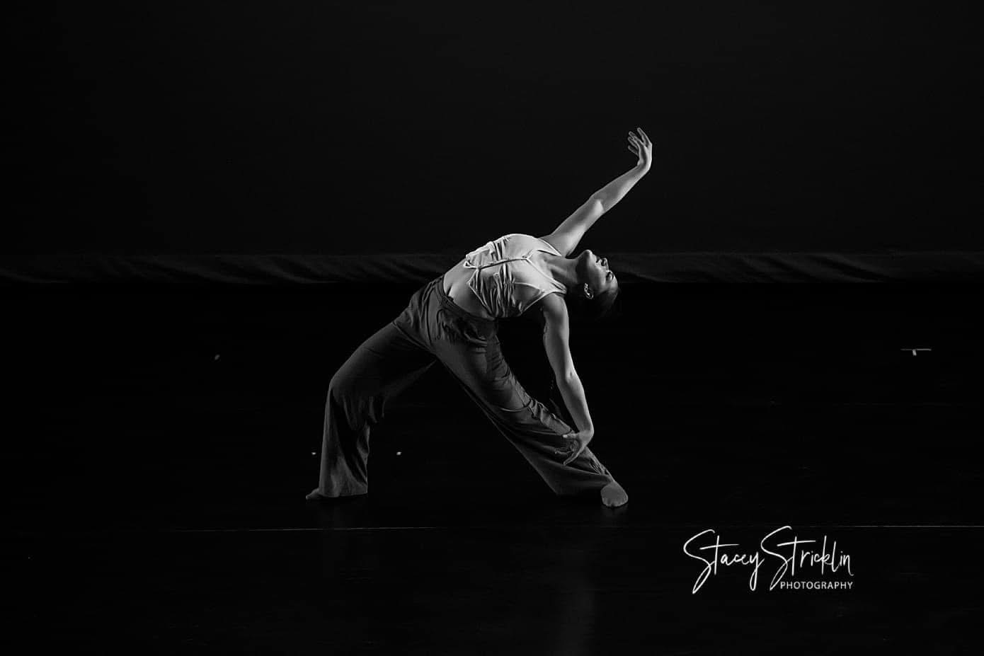 Dancer in a red costume performing under stage lights