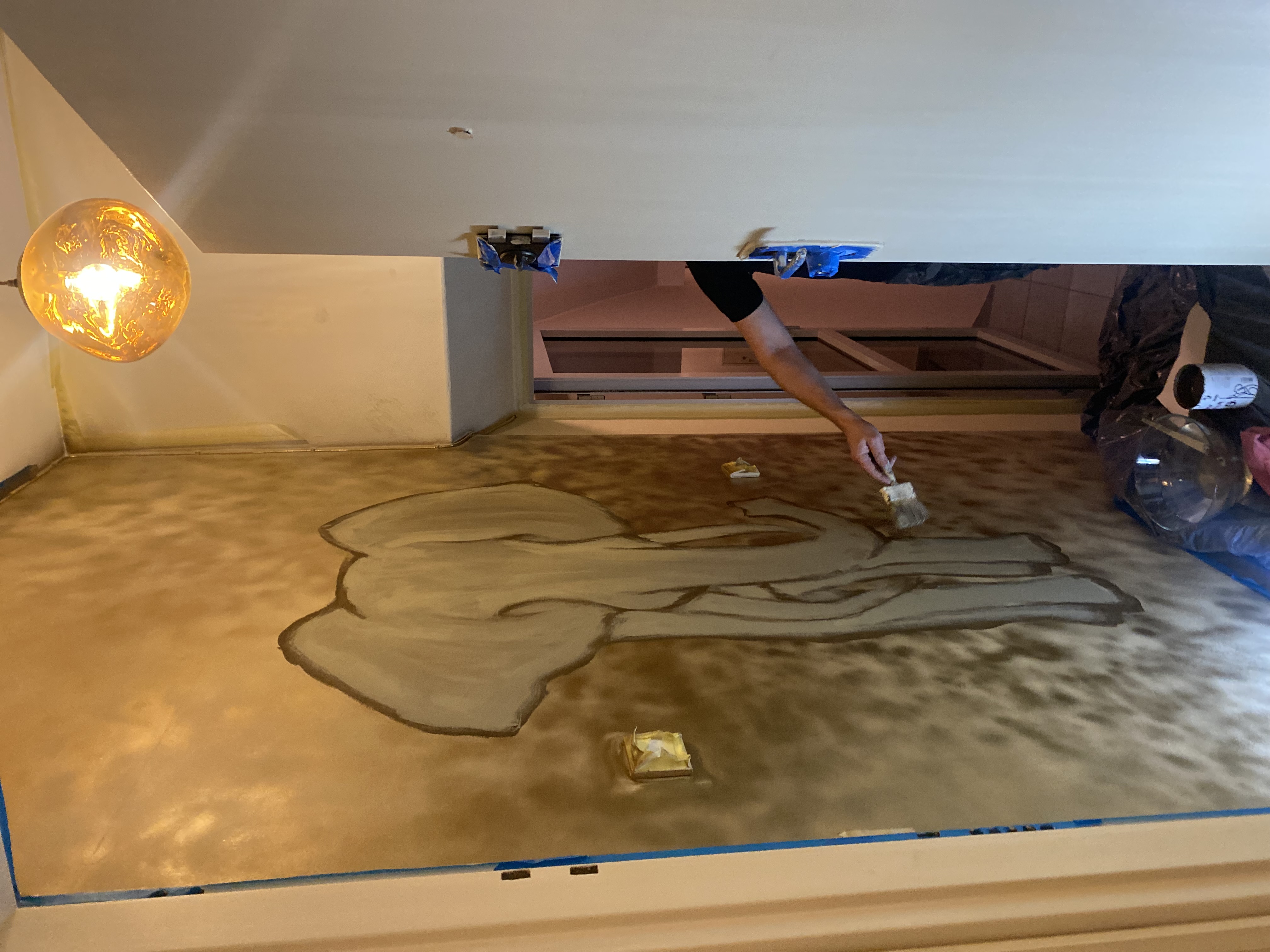 Hand-painting a custom elephant mural for a client's entryway. The metallic faux finish creates depth and drama.