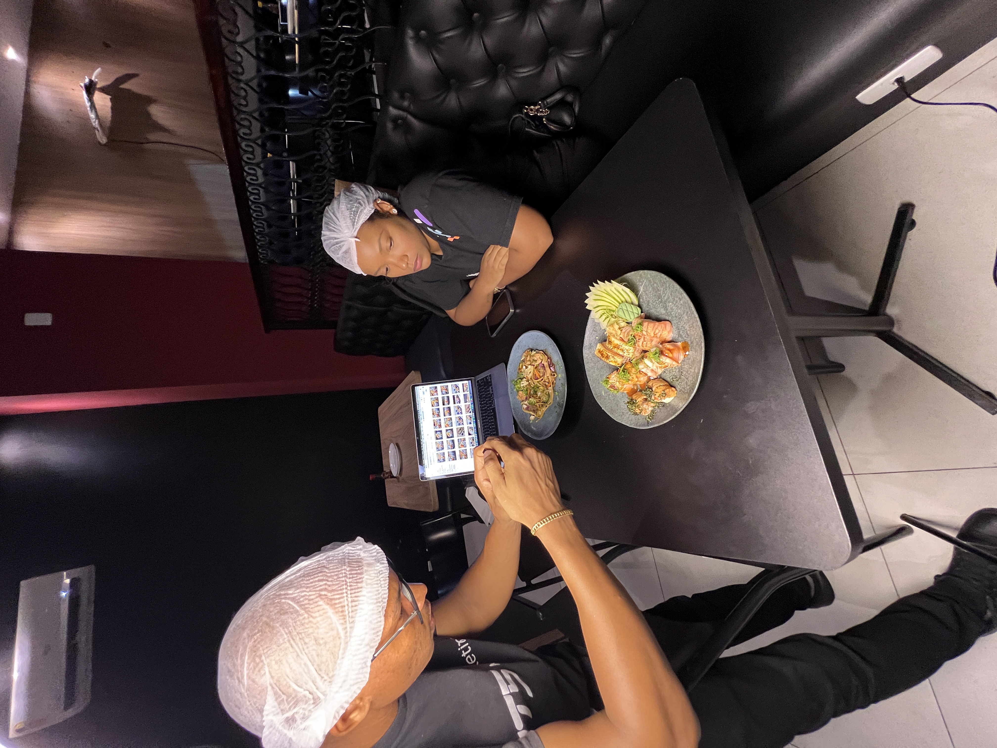 Equipe IT5 fotografando comida japonesa com laptop