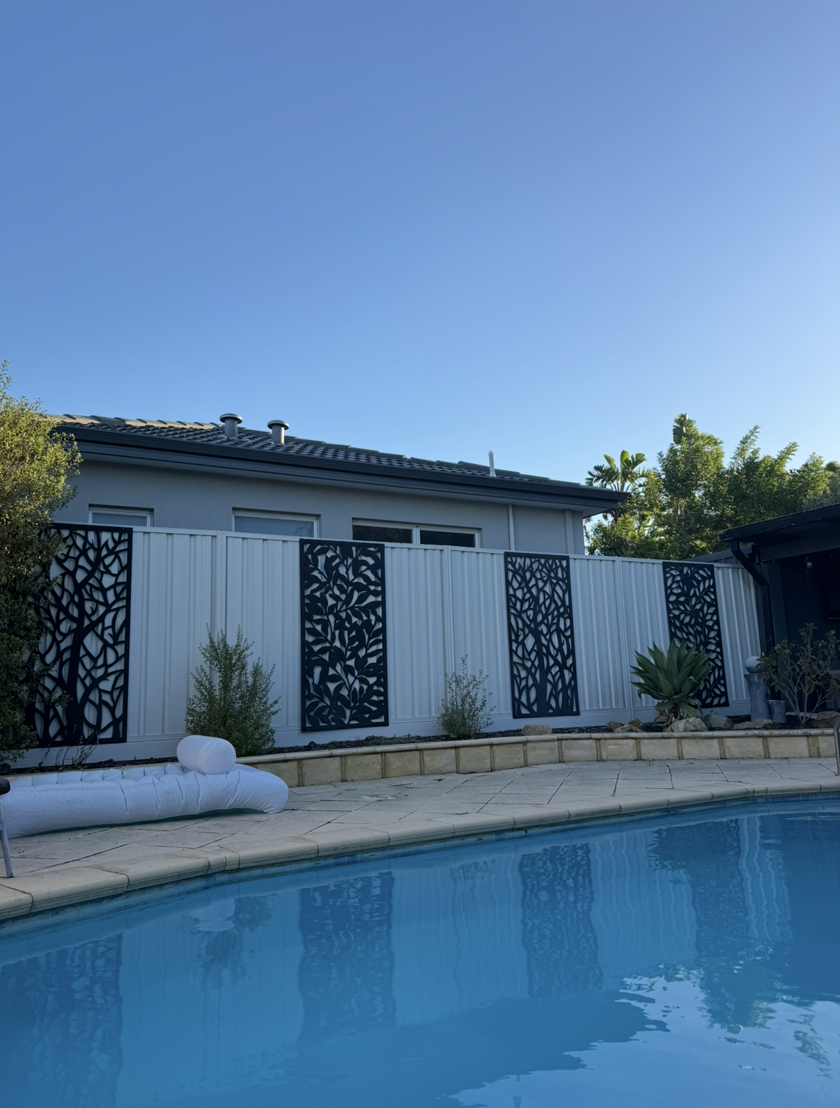 Professional colorbond fence installation with decorative panels by pool