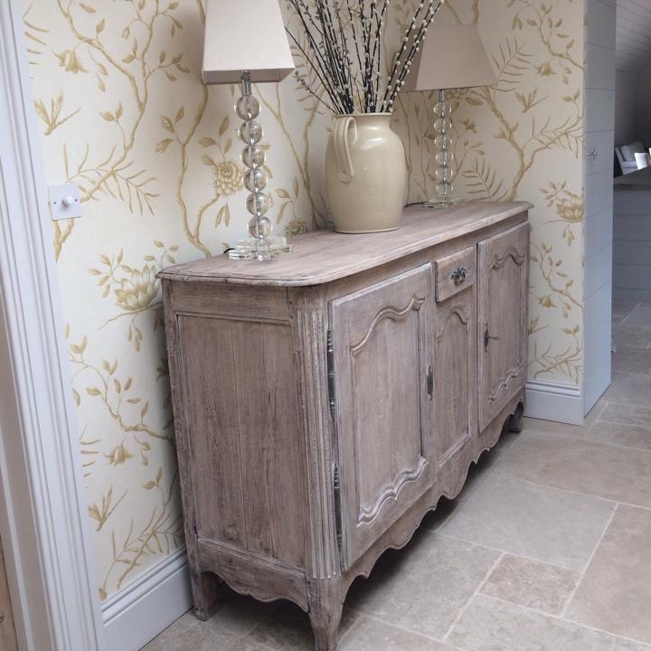 Rustic sideboard against floral wallpaper
