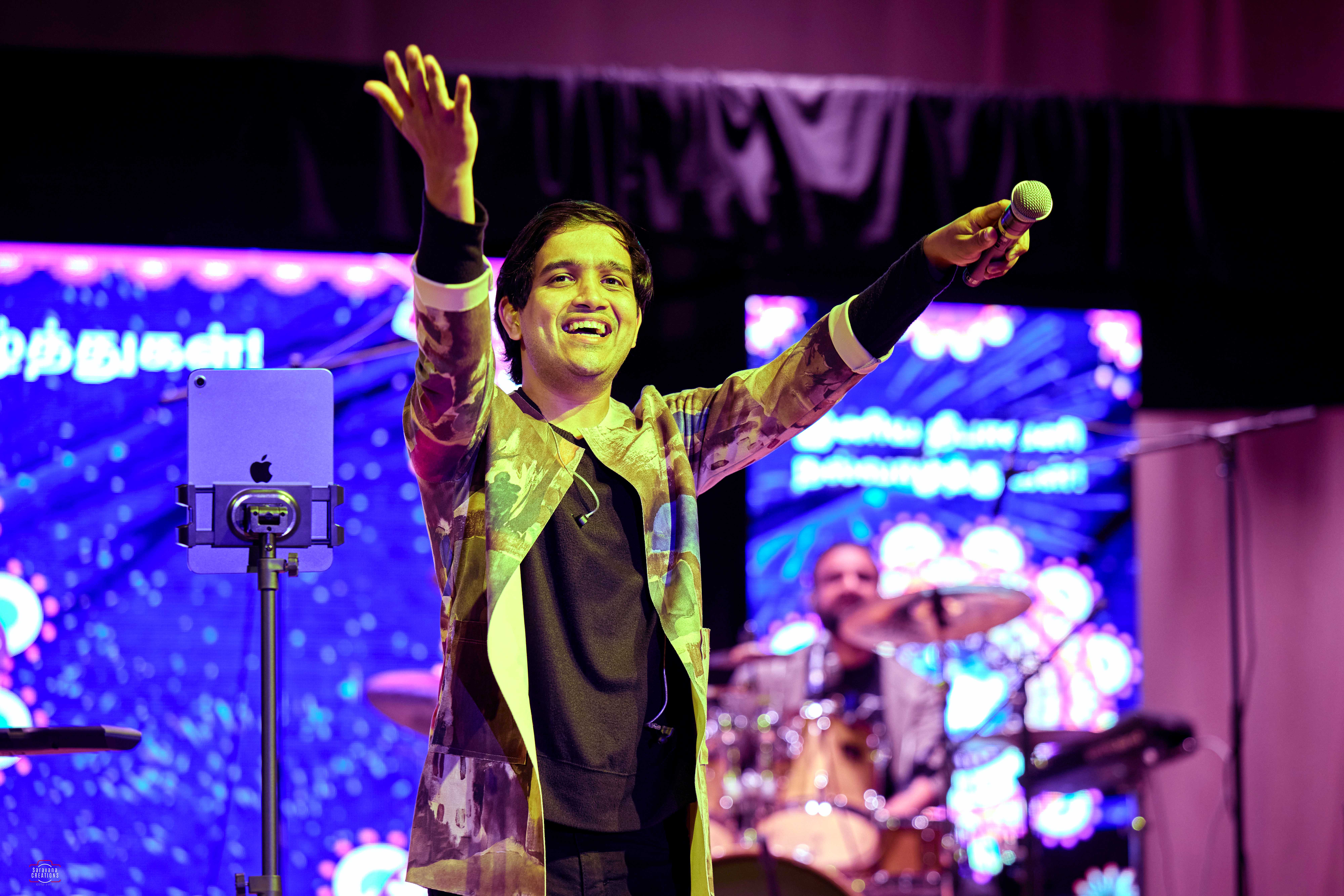 Singer performing with arms raised on stage