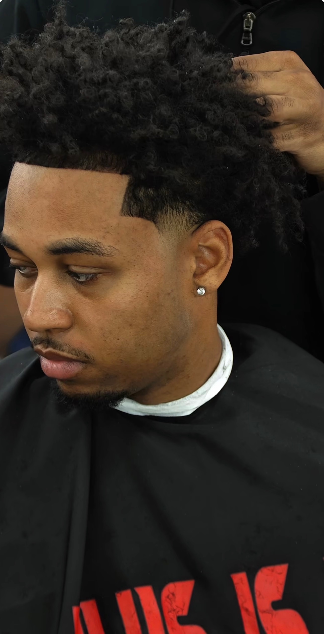 Curly top haircut with a crisp fade
