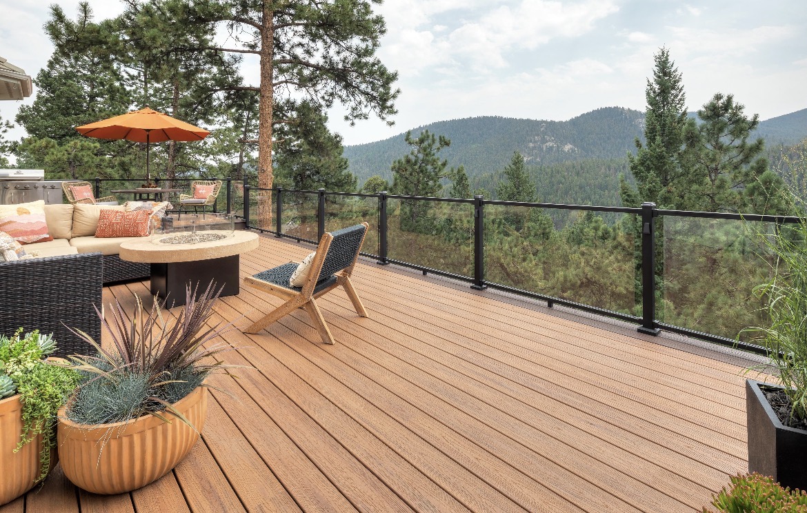 Modern deck with mountain views, glass railings, and outdoor furniture