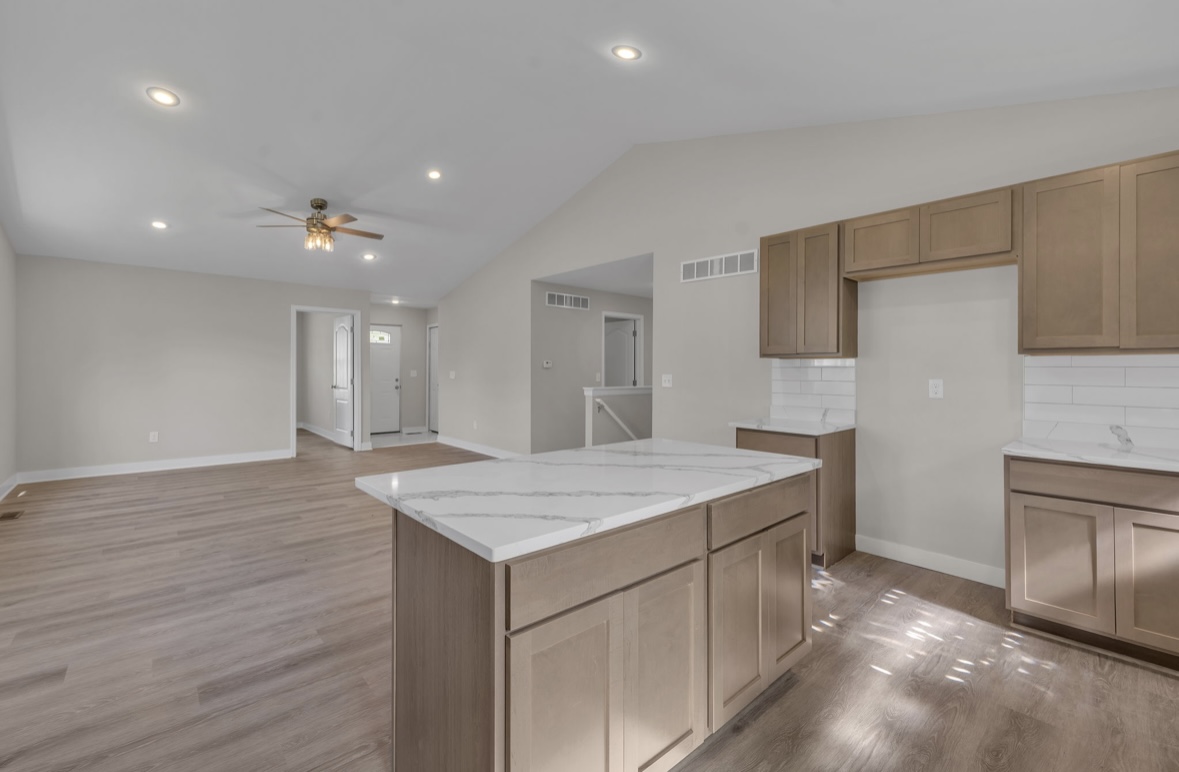 Open concept living and kitchen area with vaulted ceiling and center island