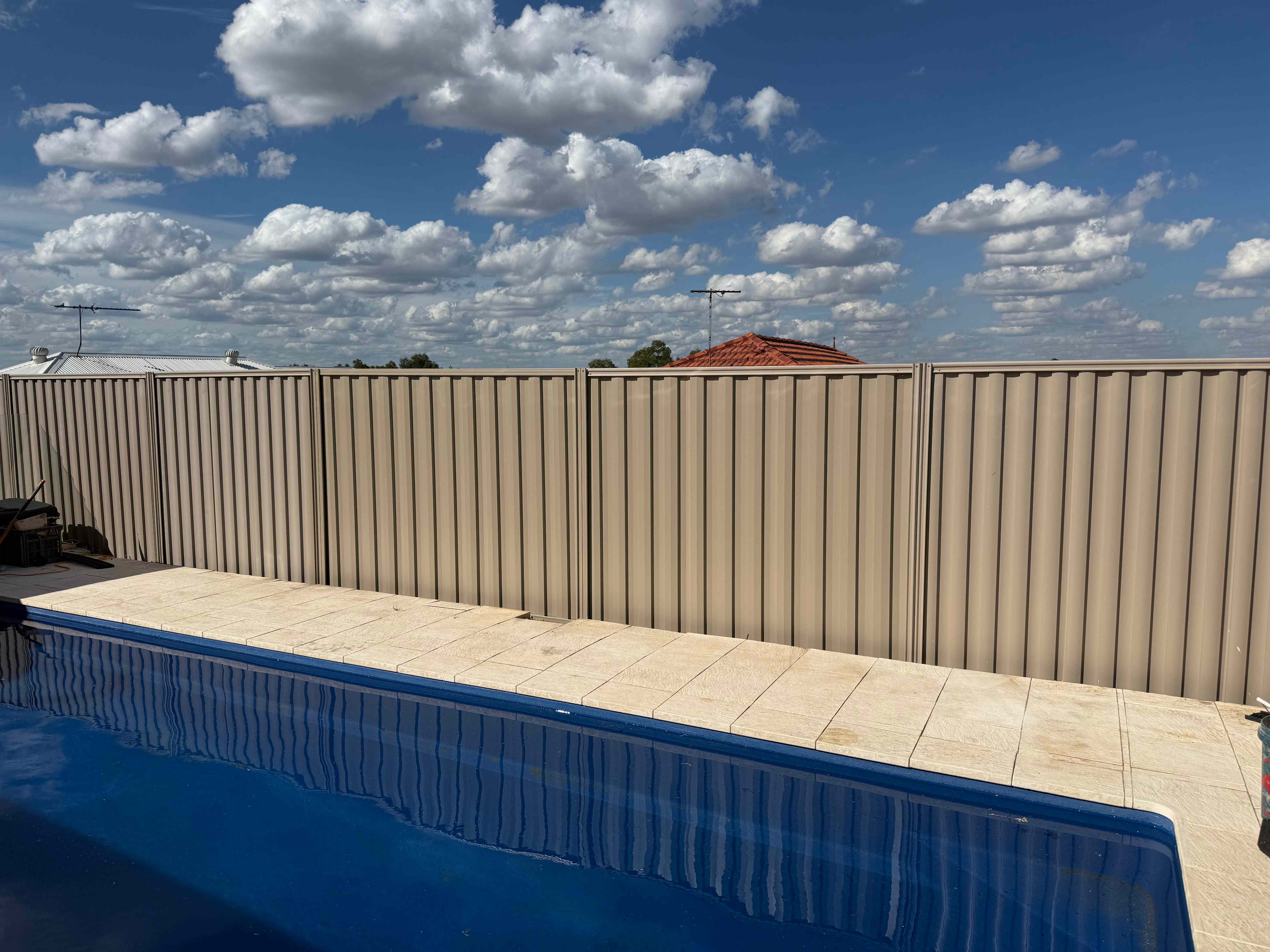 Beige colorbond fence installation around swimming pool