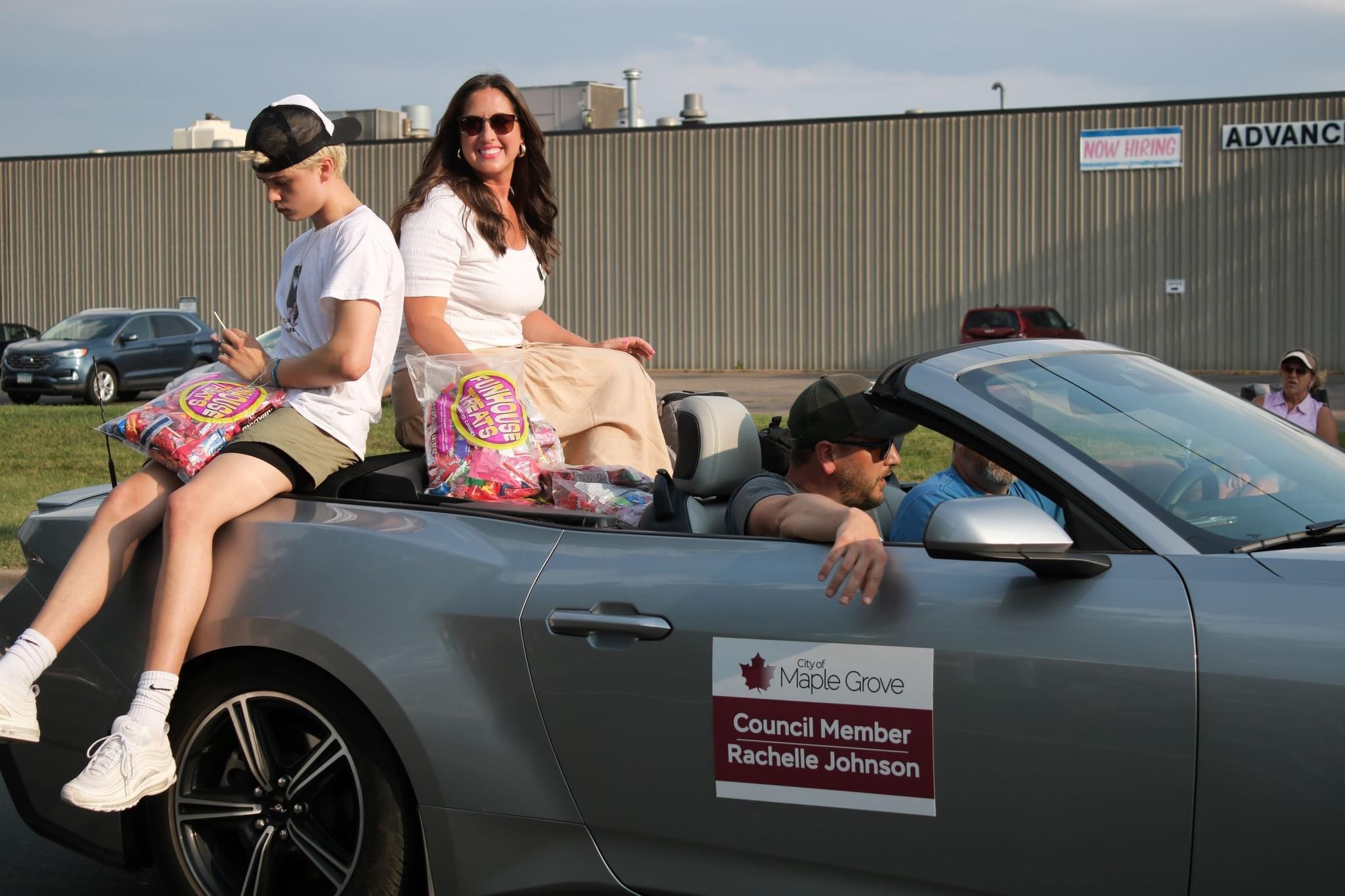 Rachelle in convertible at community event passing out candy