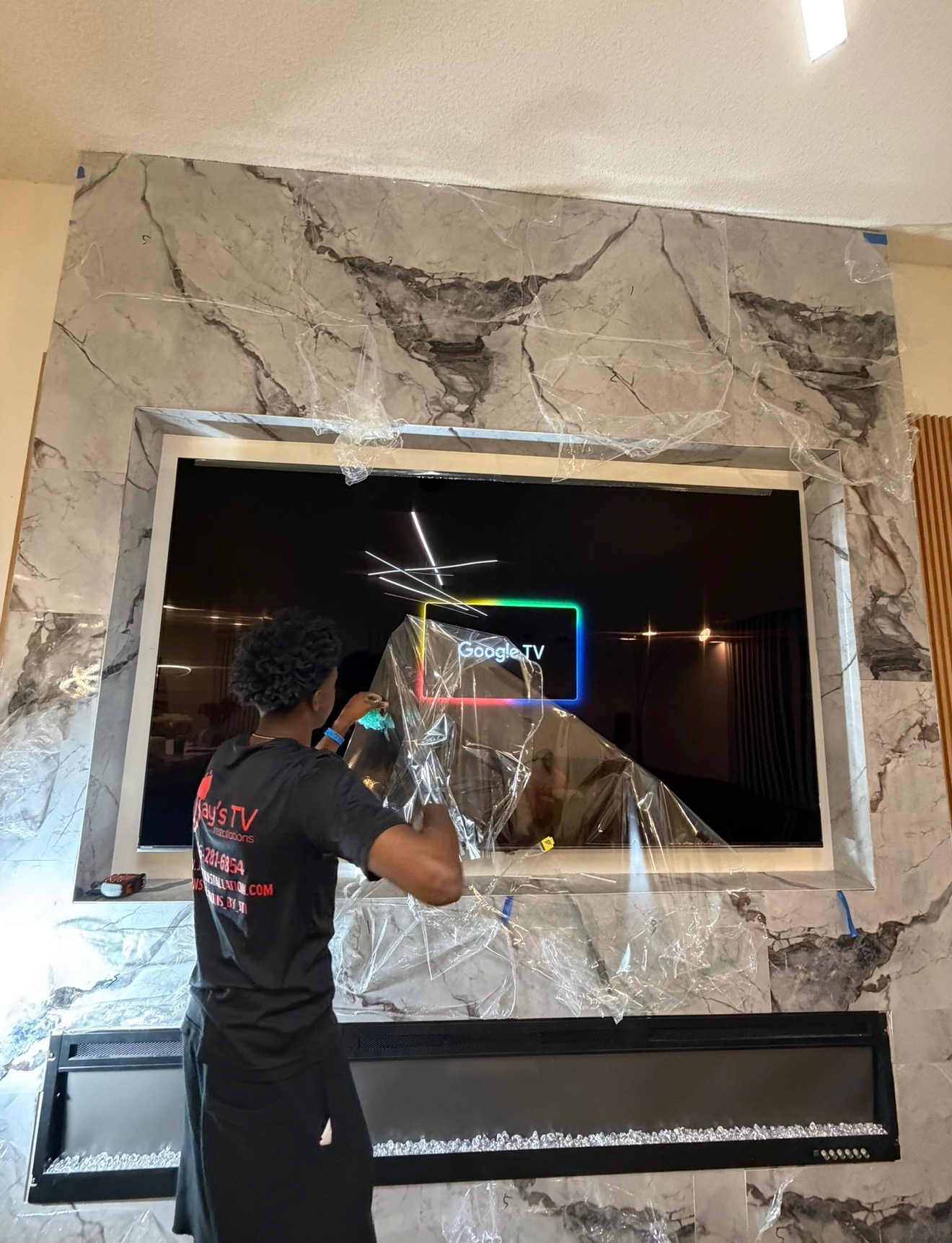 TV installation on marble wall with fireplace