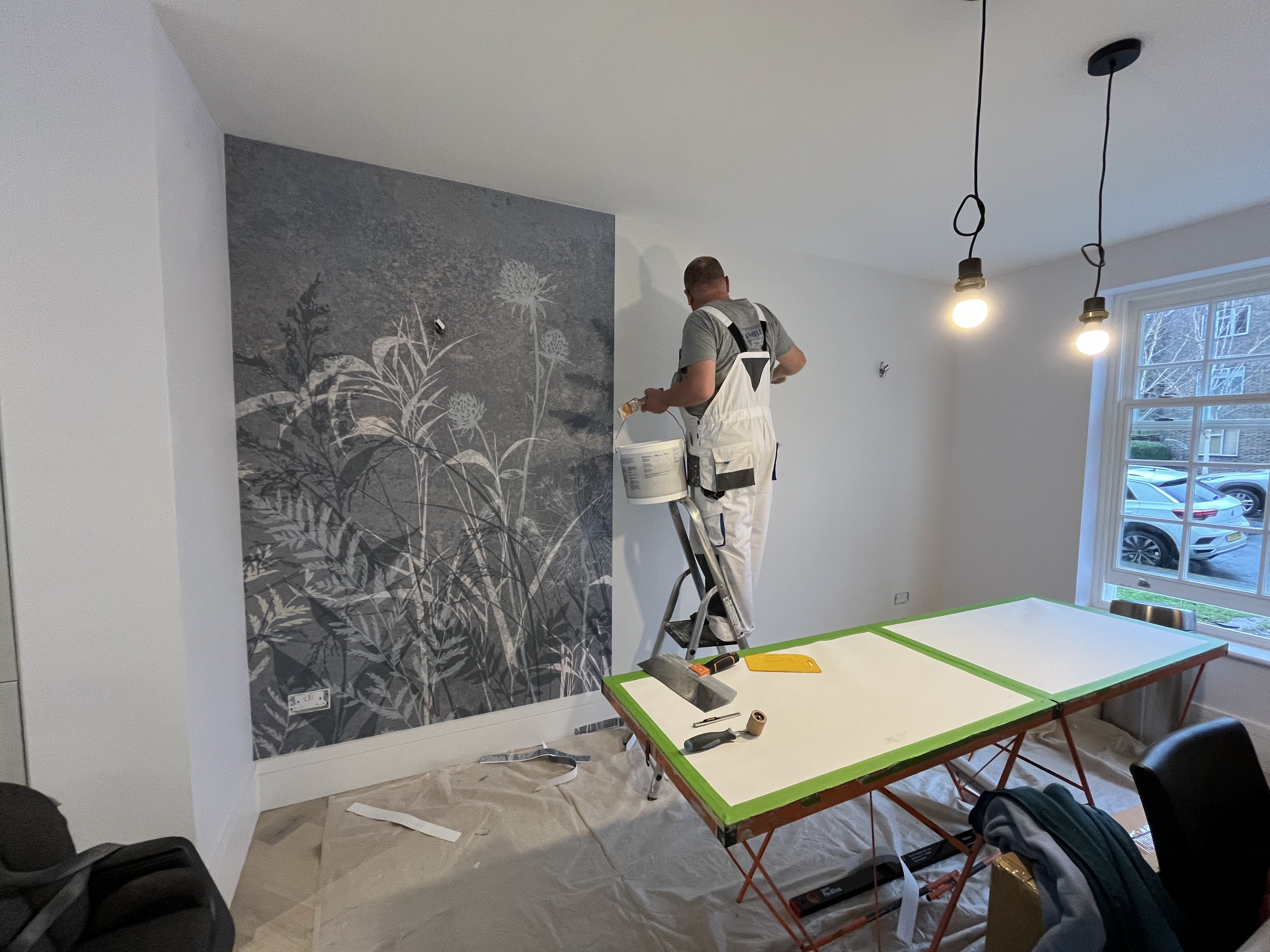 Decorator installing botanical mural