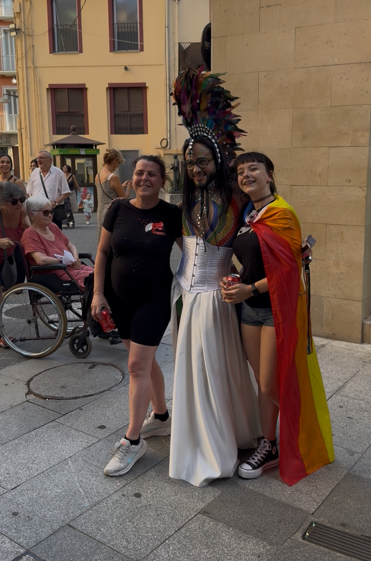 Migantito con tocado de plumas junto a fans en la calle