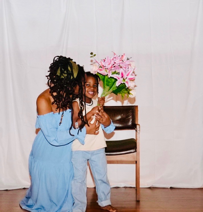Mel embracing her son with flowers
