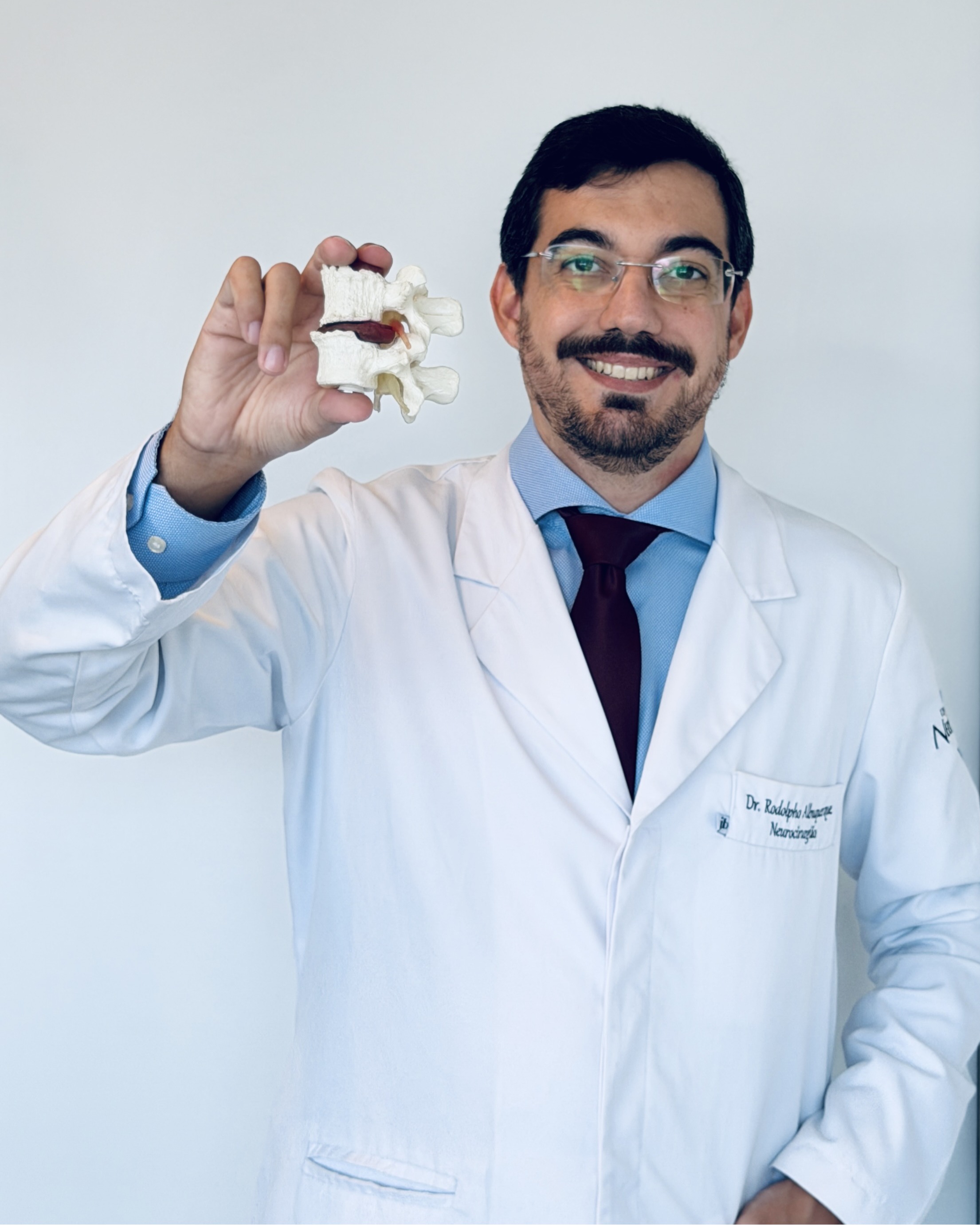 Dr. Rodolpho Albuquerque segurando modelo anatômico de vértebra