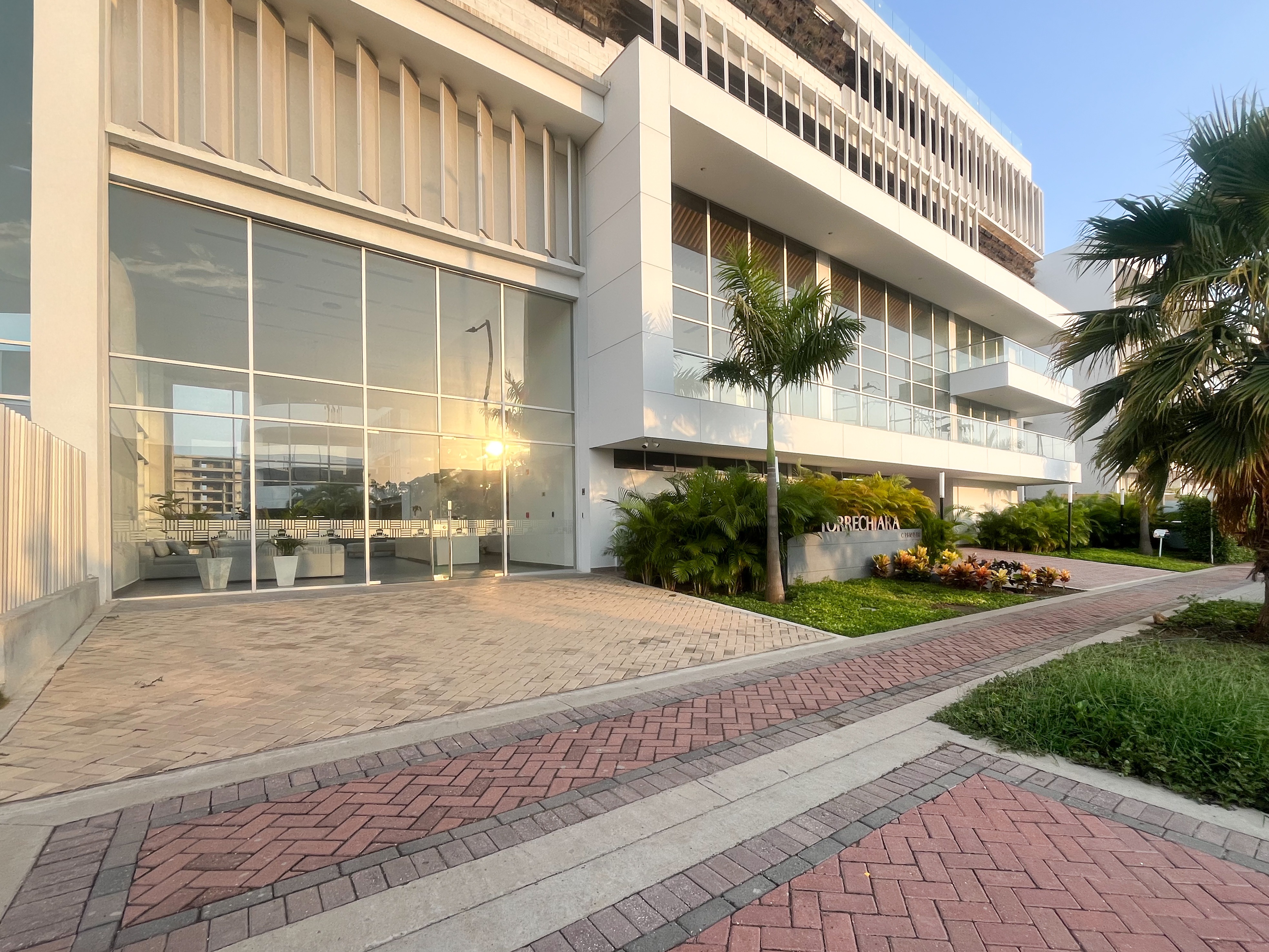 Fachada con lobby acristalado al atardecer