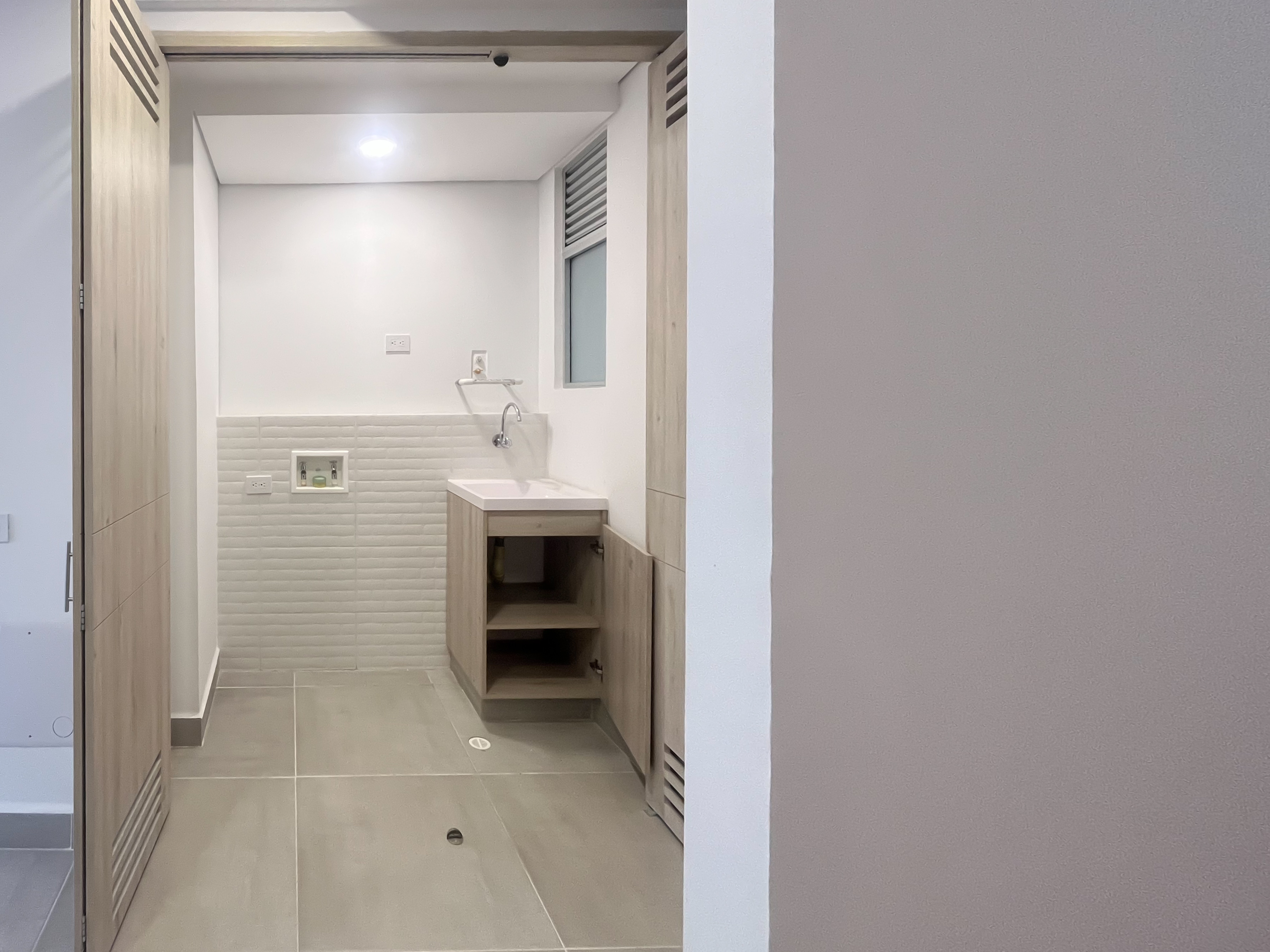 Cuarto de ropas con lavadero y mobiliario en madera