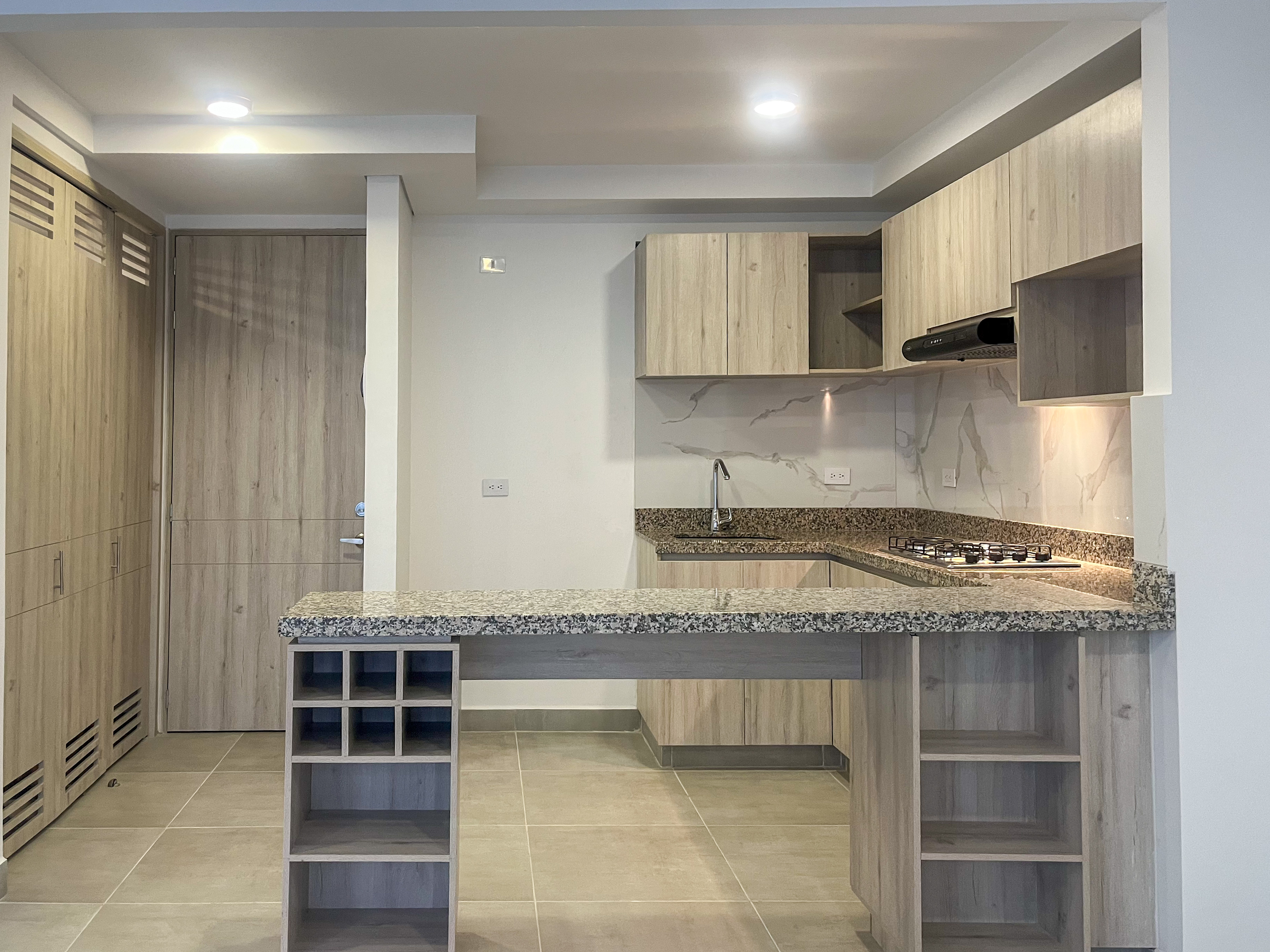 Cocina ampliada con mueble adicional y barra en granito