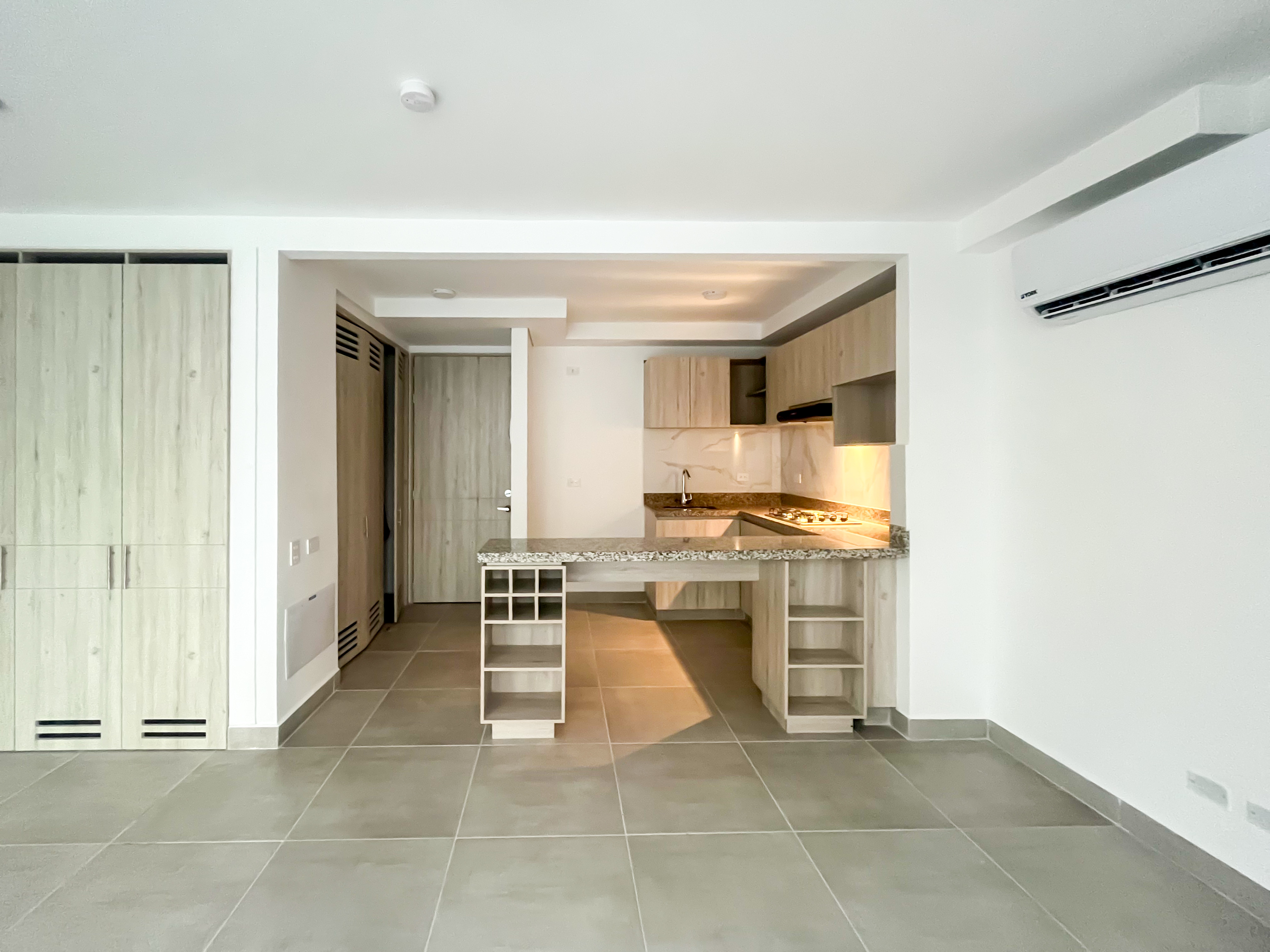 Espacio abierto integrando sala y cocina con barra en granito