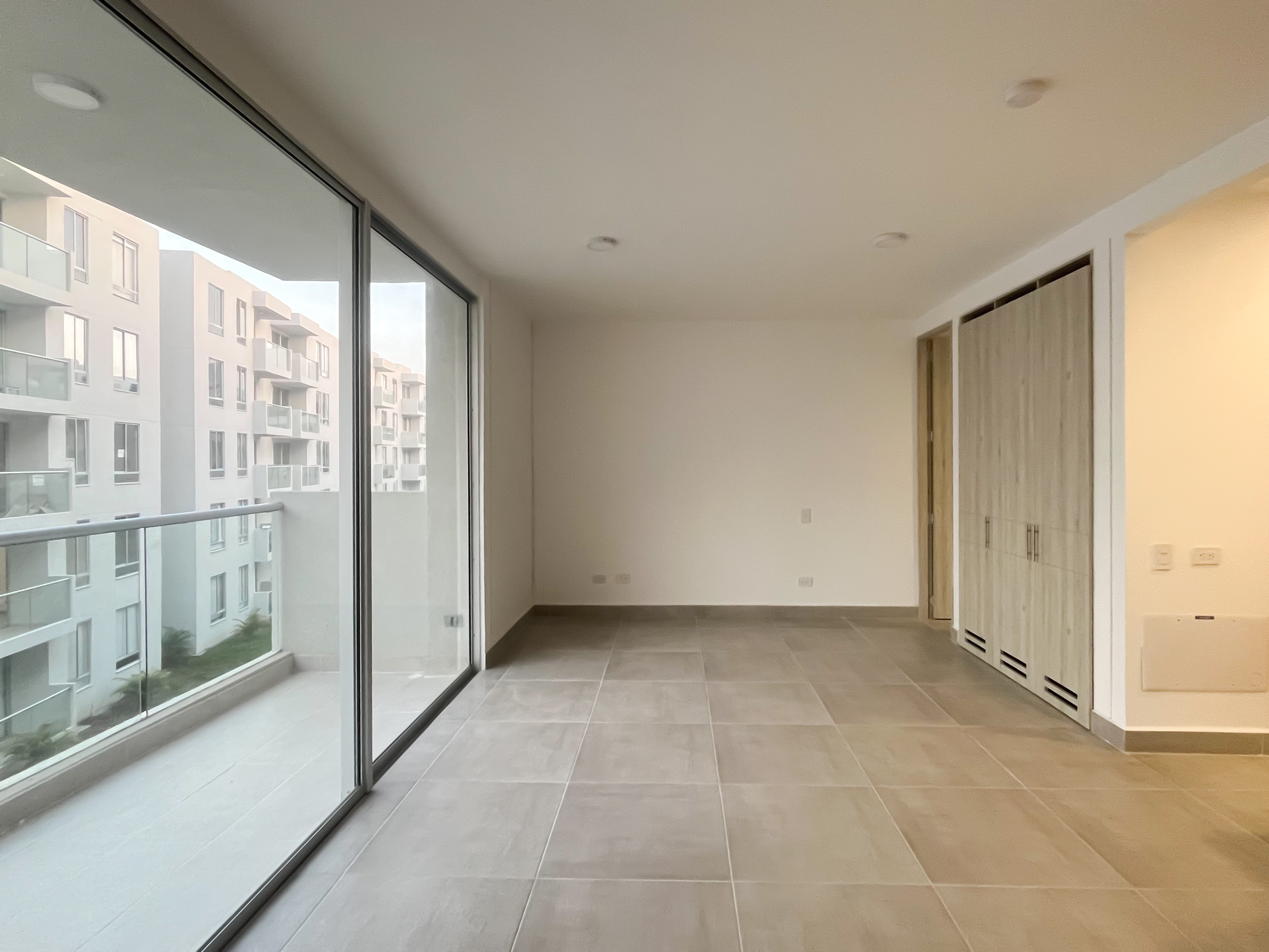 Habitación con ventanal de piso a techo y balcón