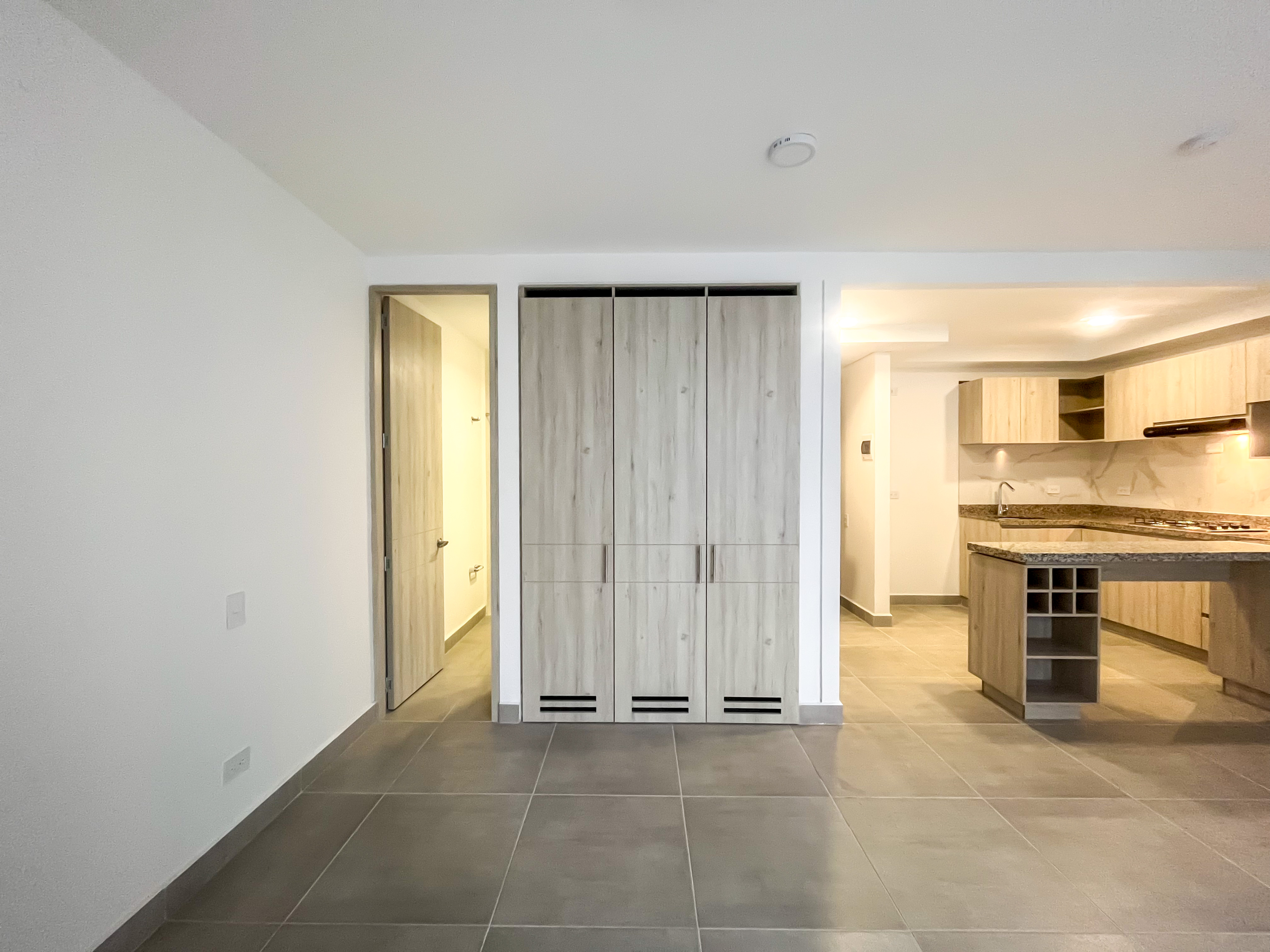 Zona íntima con clóset de madera y acceso al baño