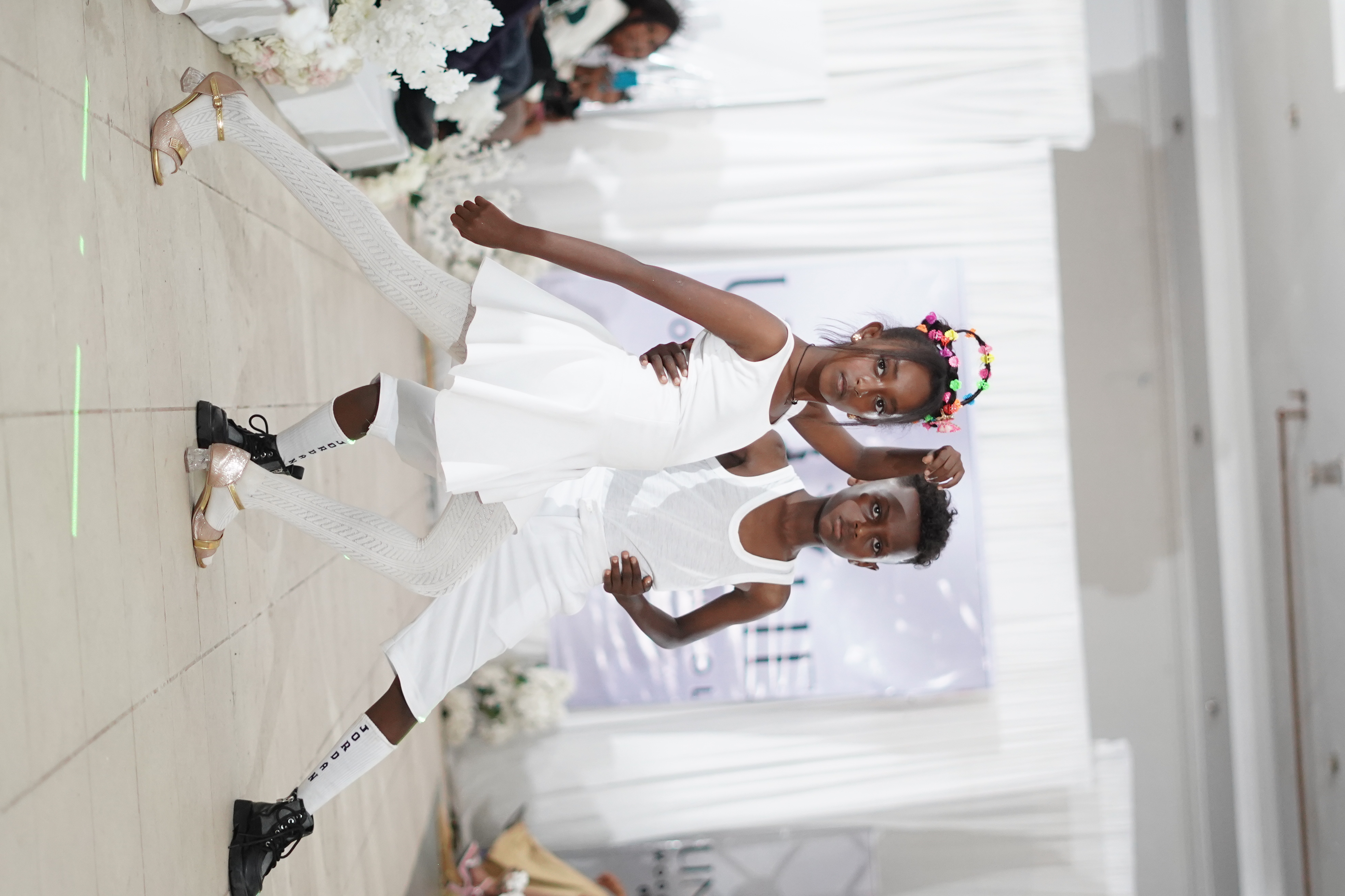 Two children presenting looks on a runway