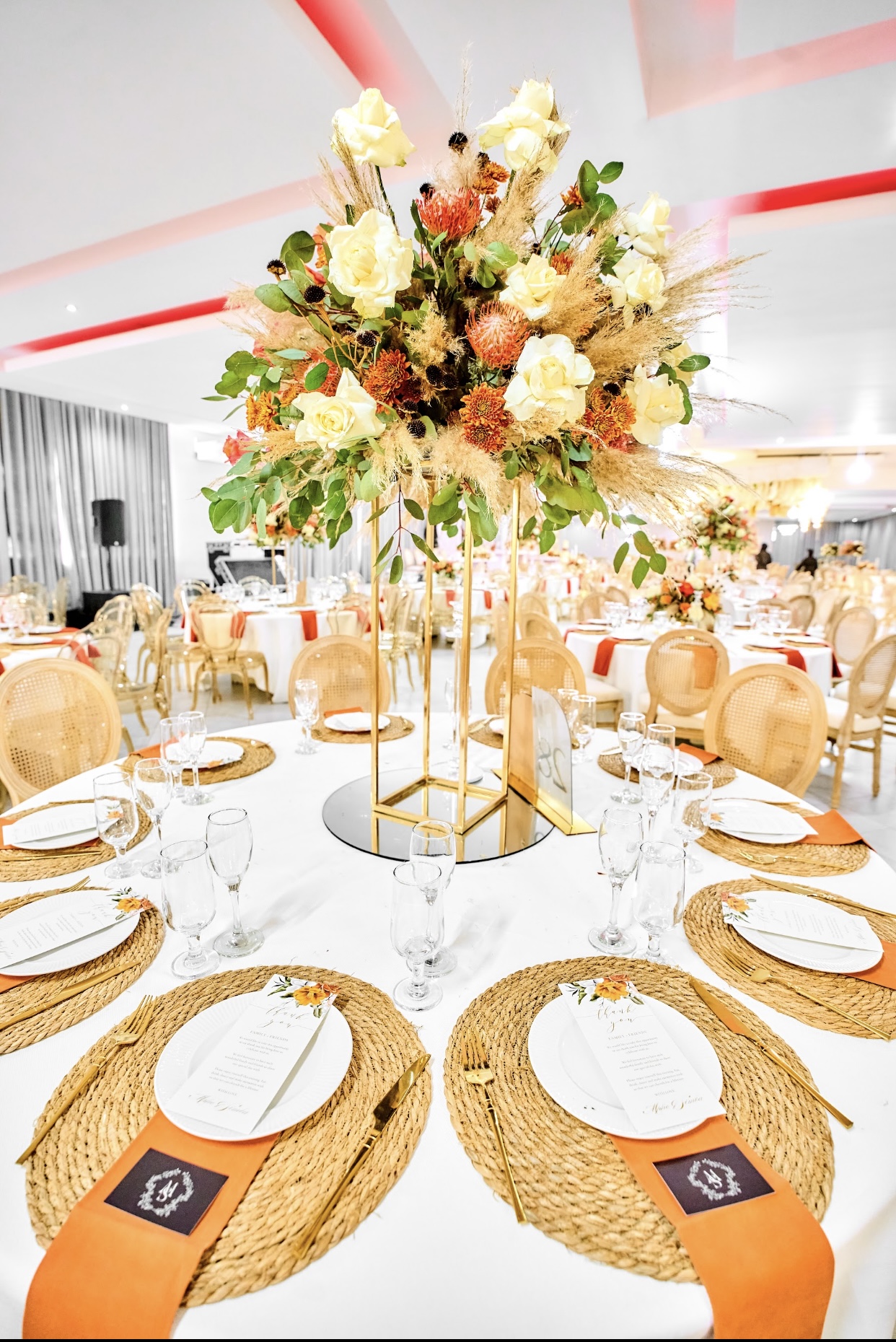 Floral wedding table setting with warm orange and gold details