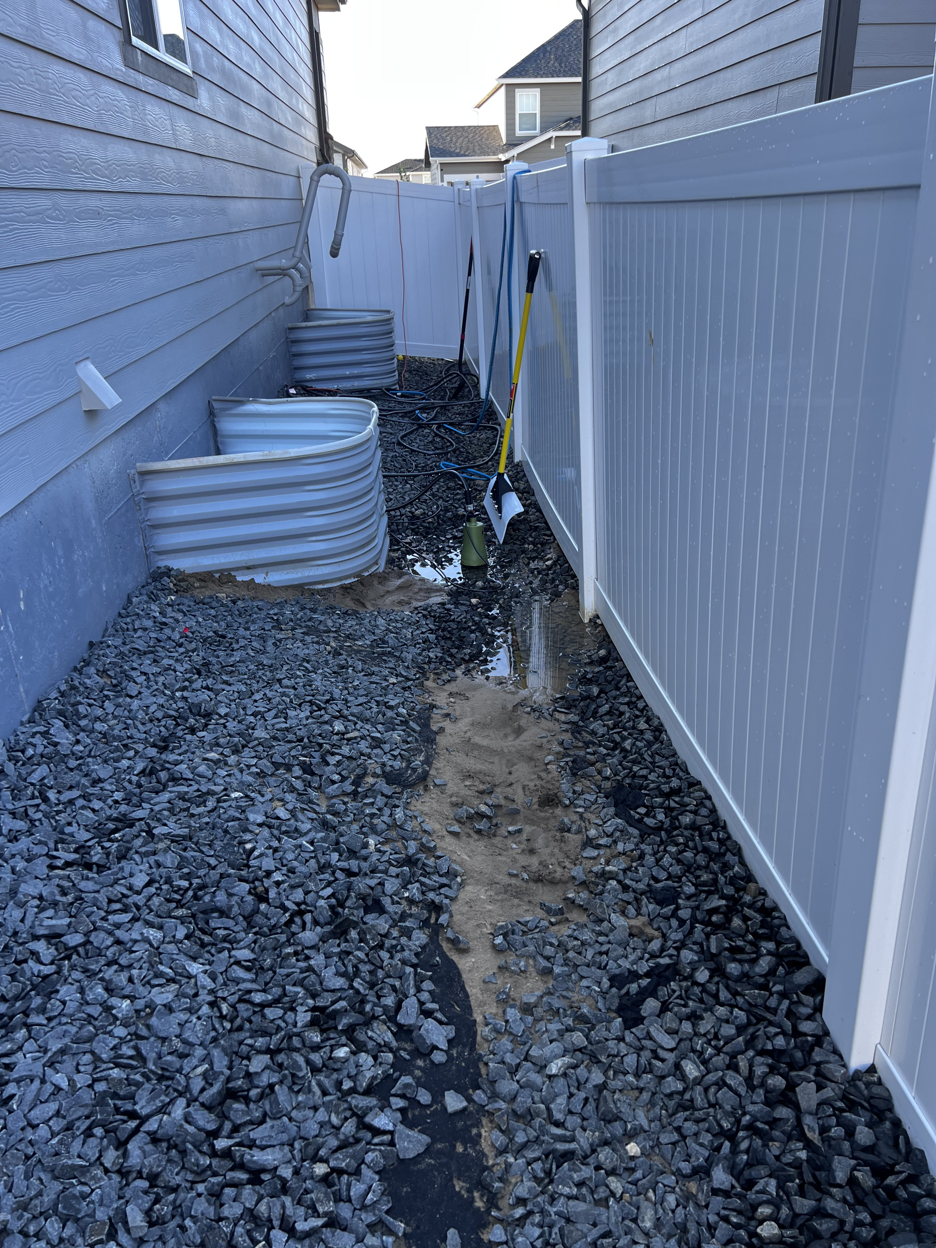 Window wells with gravel drainage along foundation