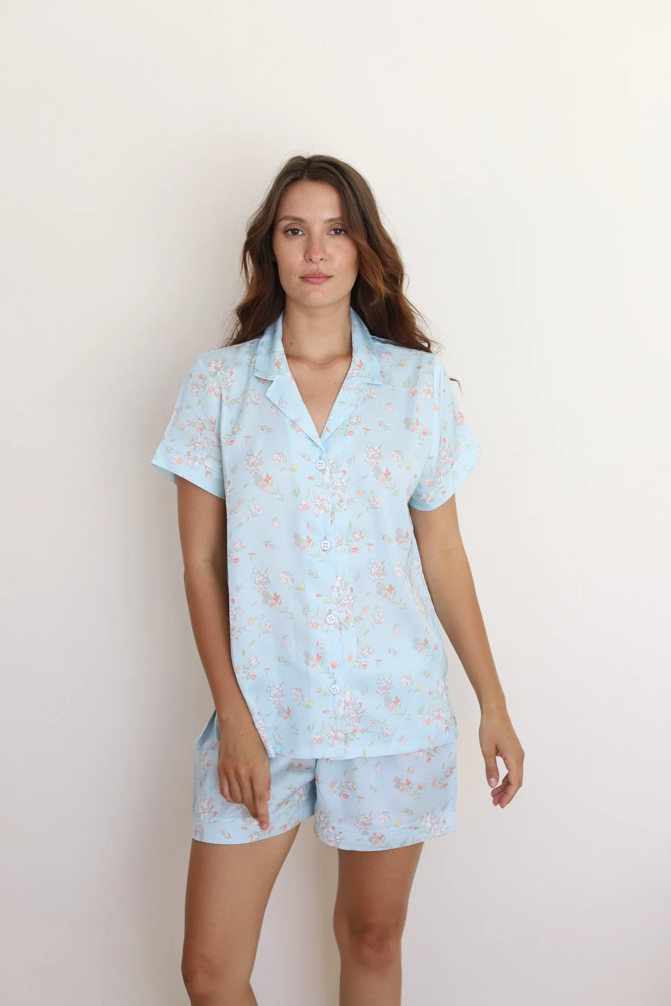 A satin light blue short-sleeve button-front top and matching shorts in a delicate floral print.