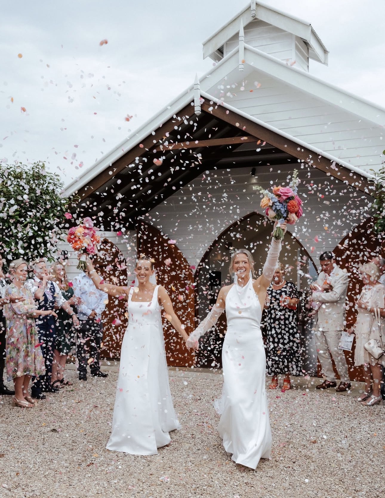 Two brides celebrating with confetti