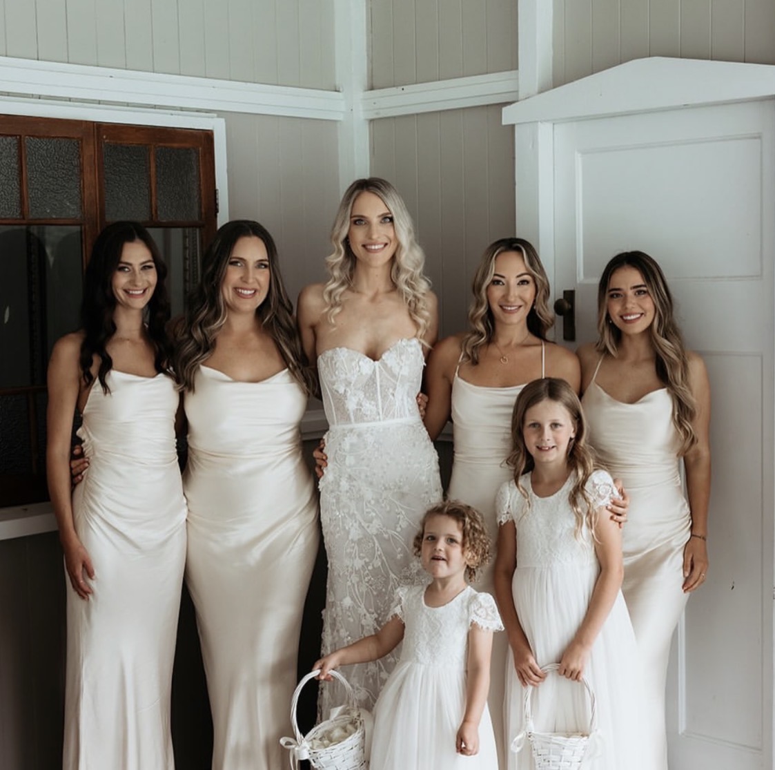 Bride with her bridesmaids and flower girls in soft neutral tones
