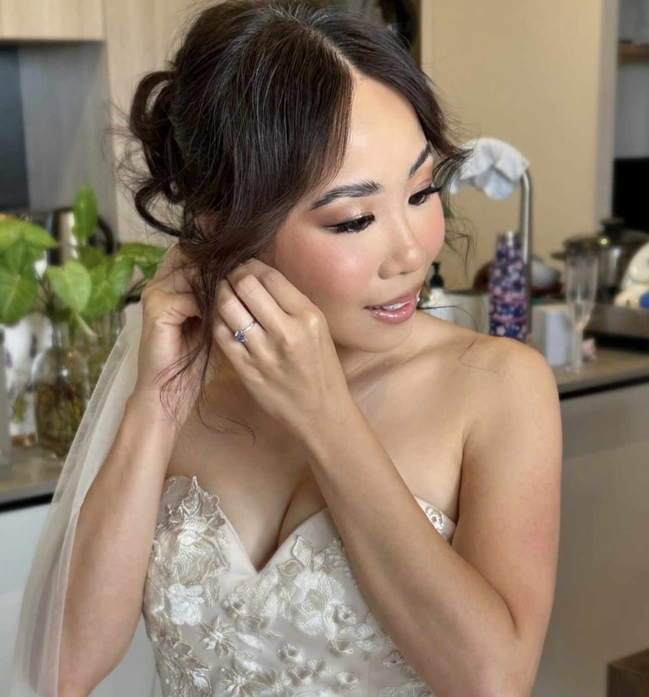 Bride putting on earrings