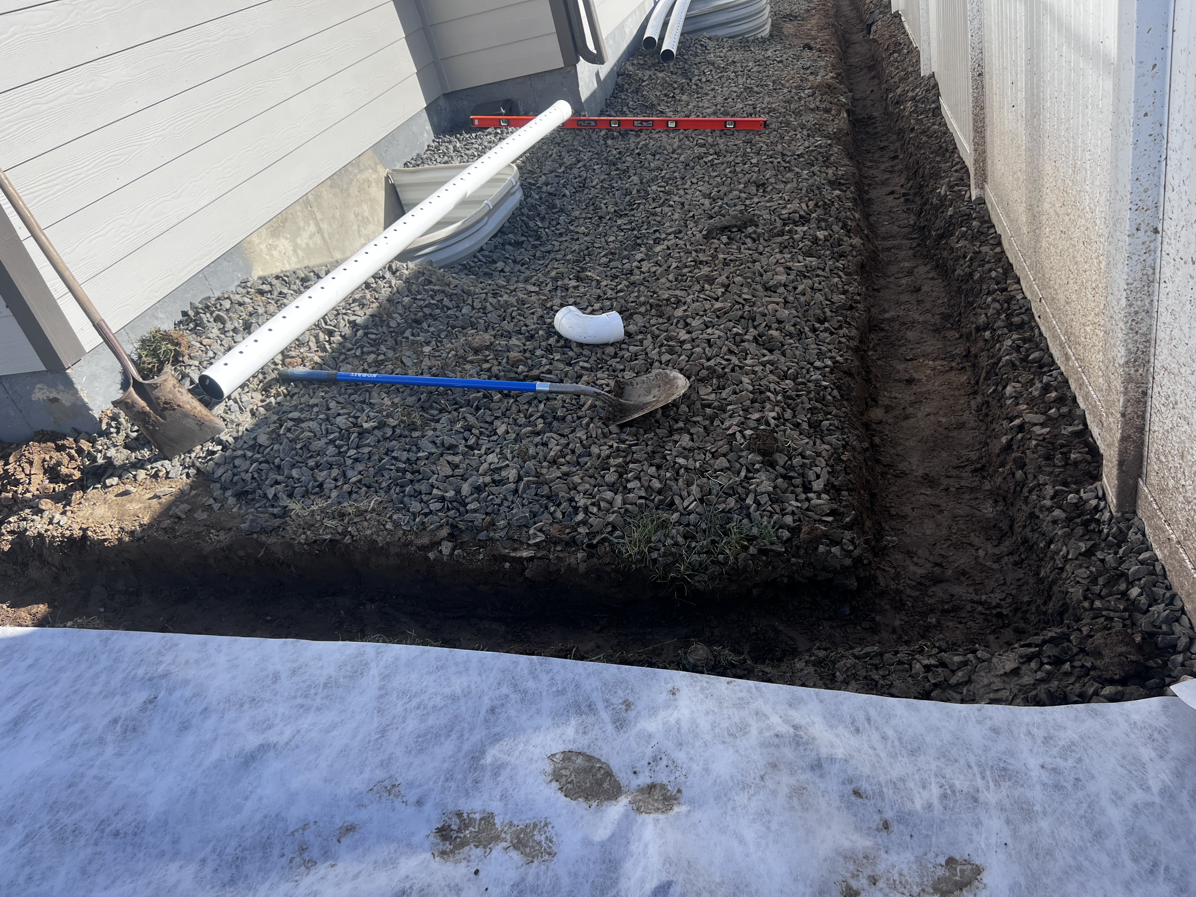 French drain gravel base with perforated pipe and level