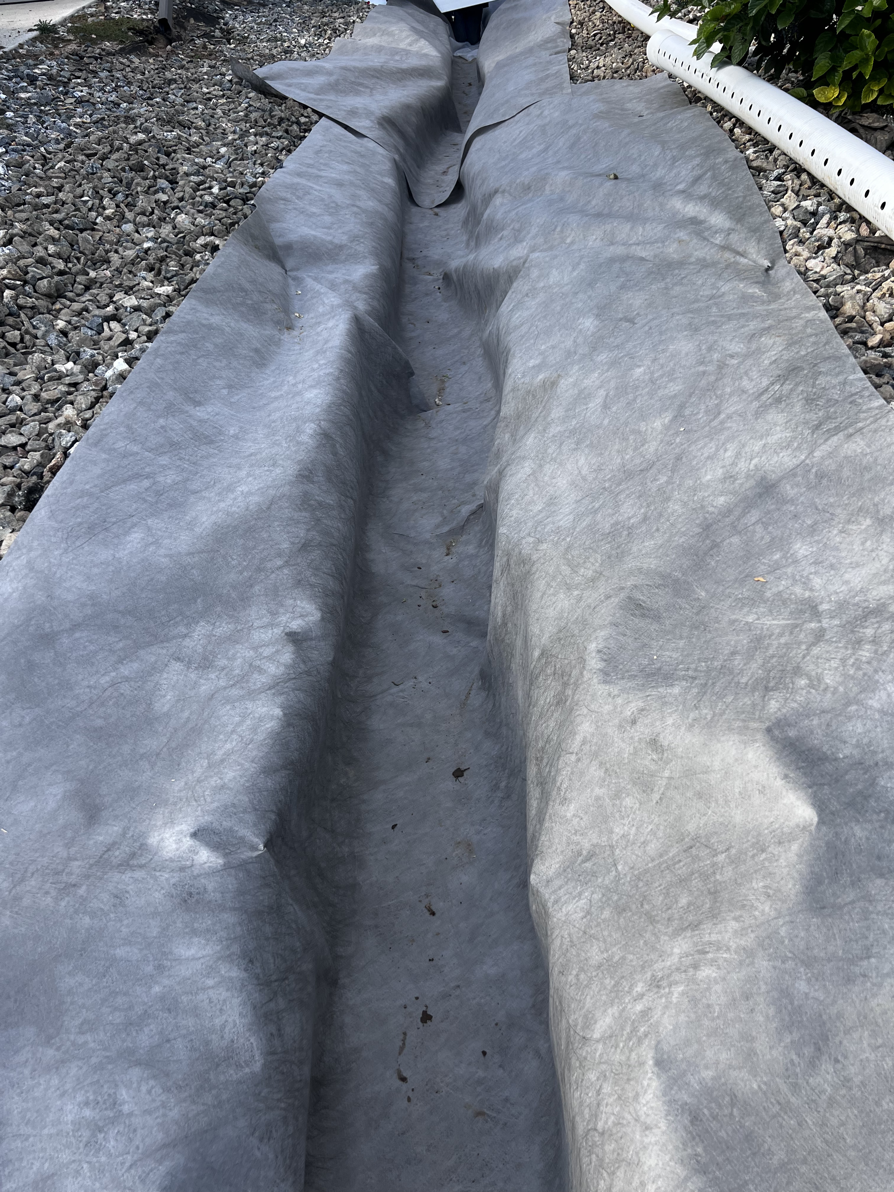 Filter fabric lined trench with perforated drain pipe