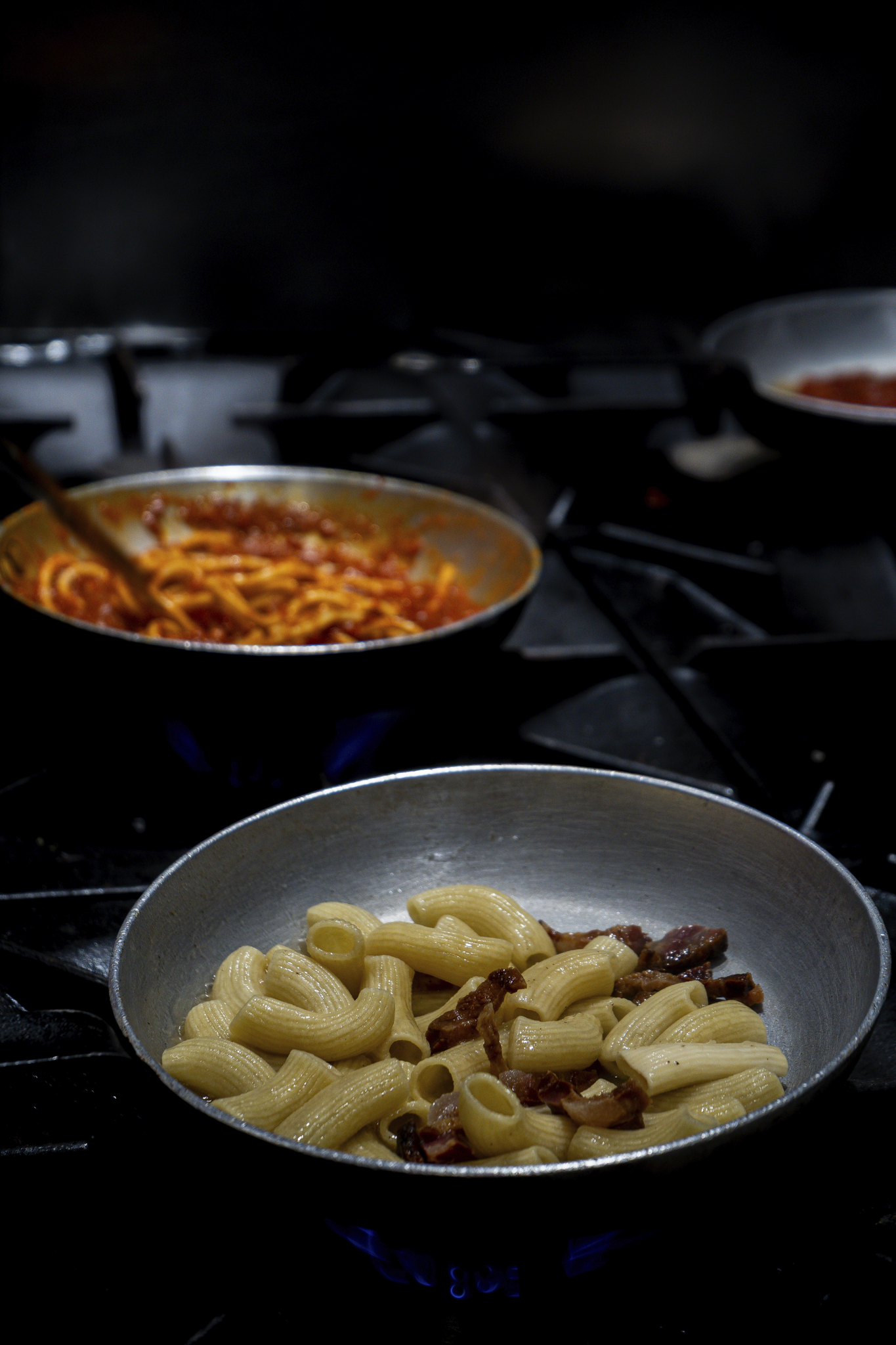 Sartenes con pasta durante el trabajo en cocina.