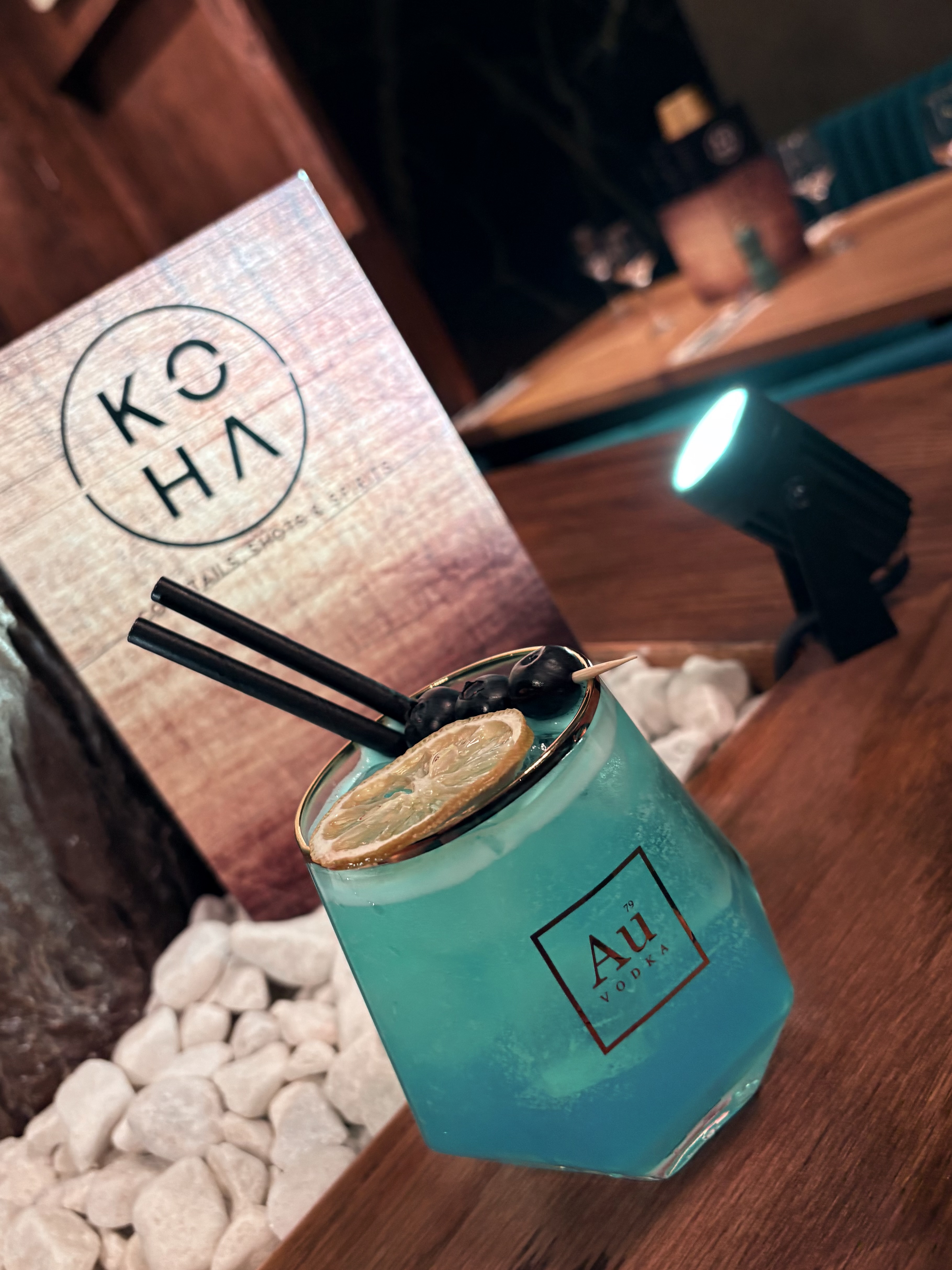 Blue lagoon cocktail in Au Vodka glass with lemon garnish