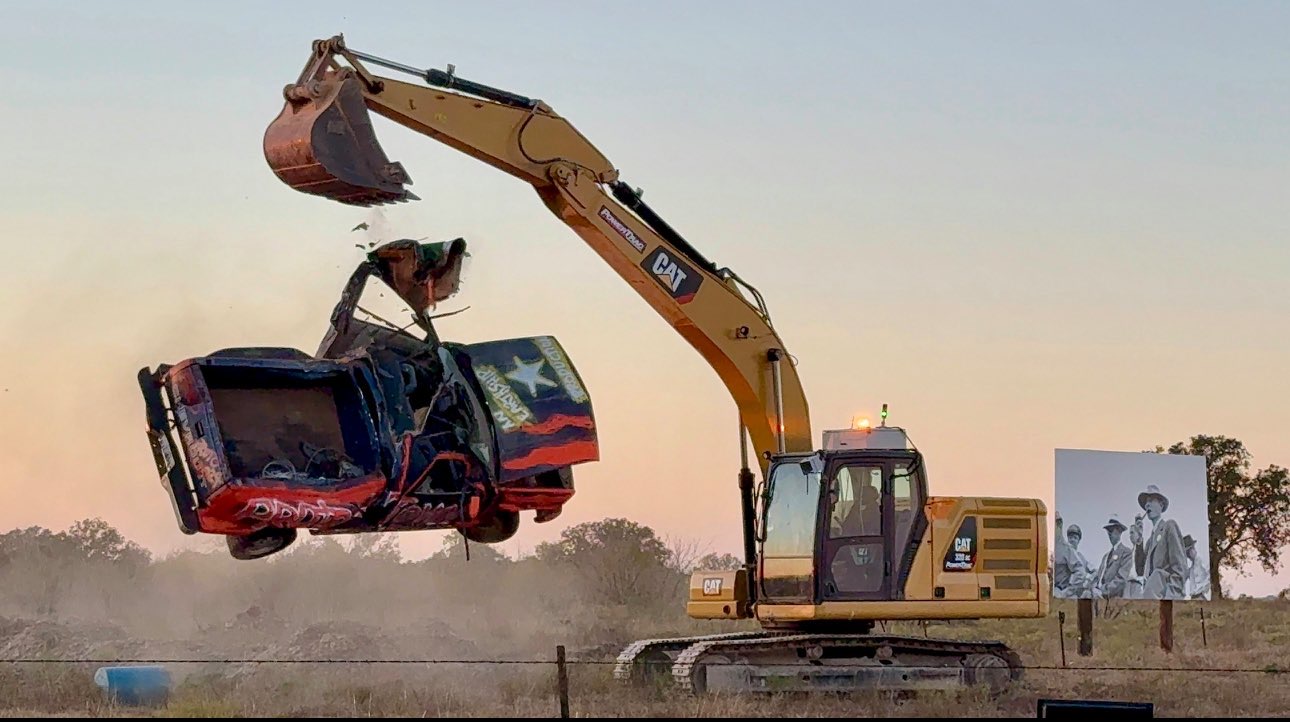 CAT excavator crushing a vehicle