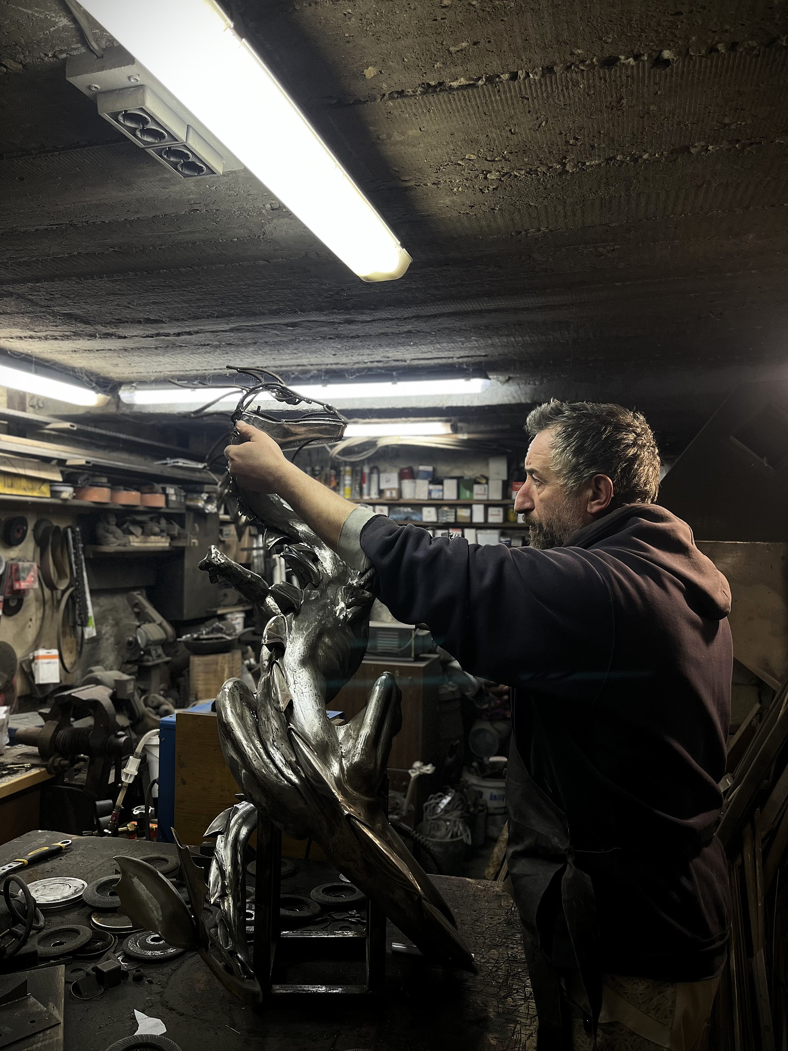 Todor Tsolov assembling a metal sculpture in the workshop