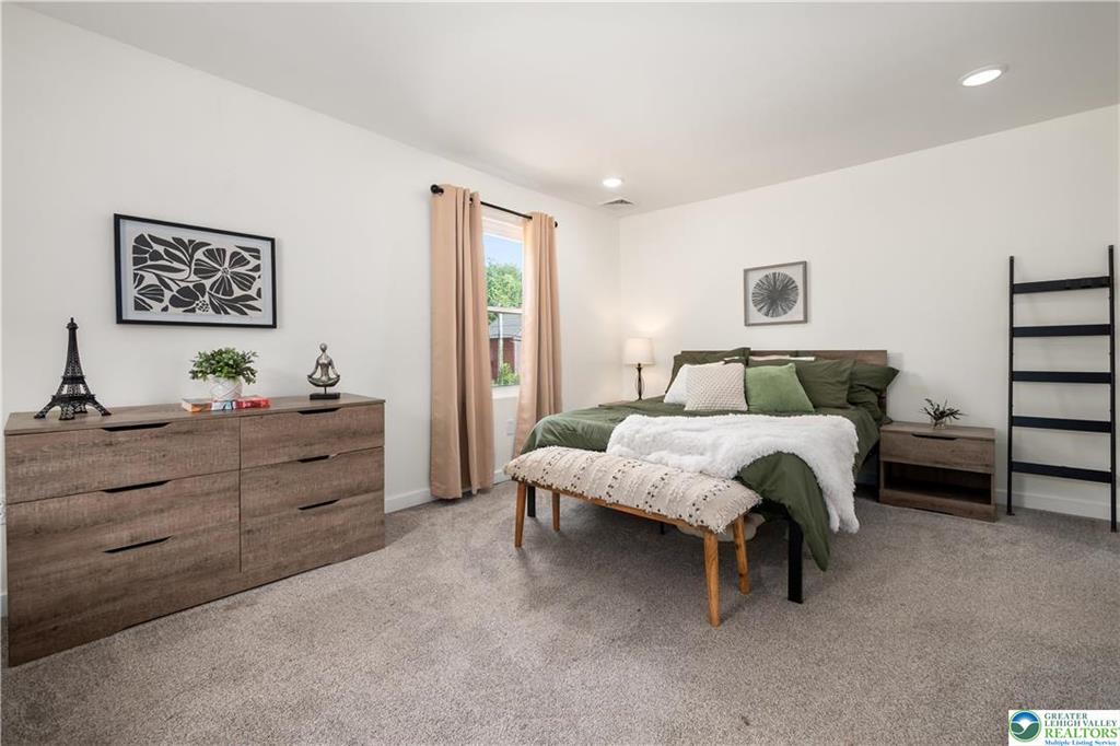 Neutral wall-to-wall carpet in a furnished bedroom