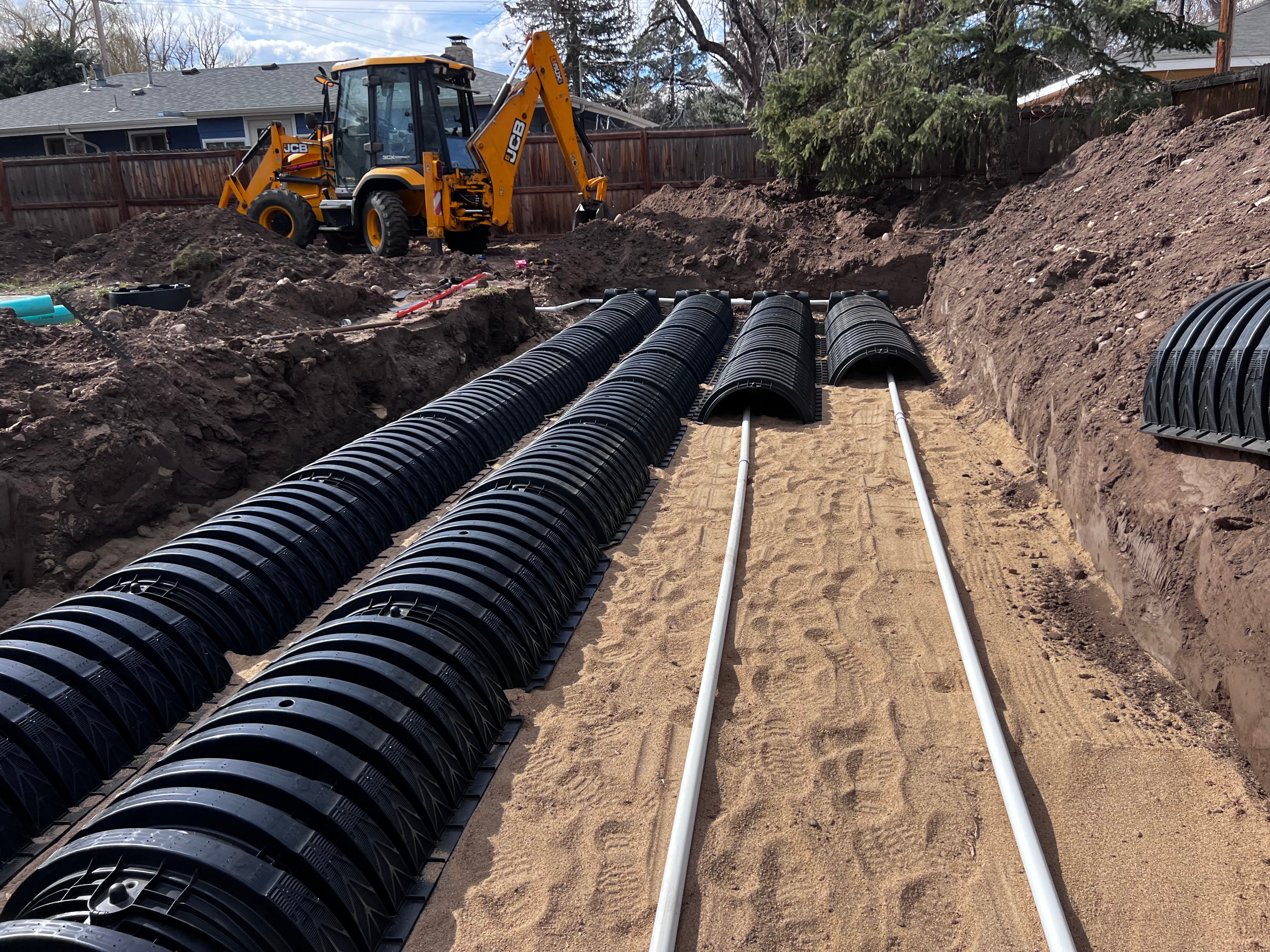 Infiltrator chamber septic leach field installation with JCB excavator